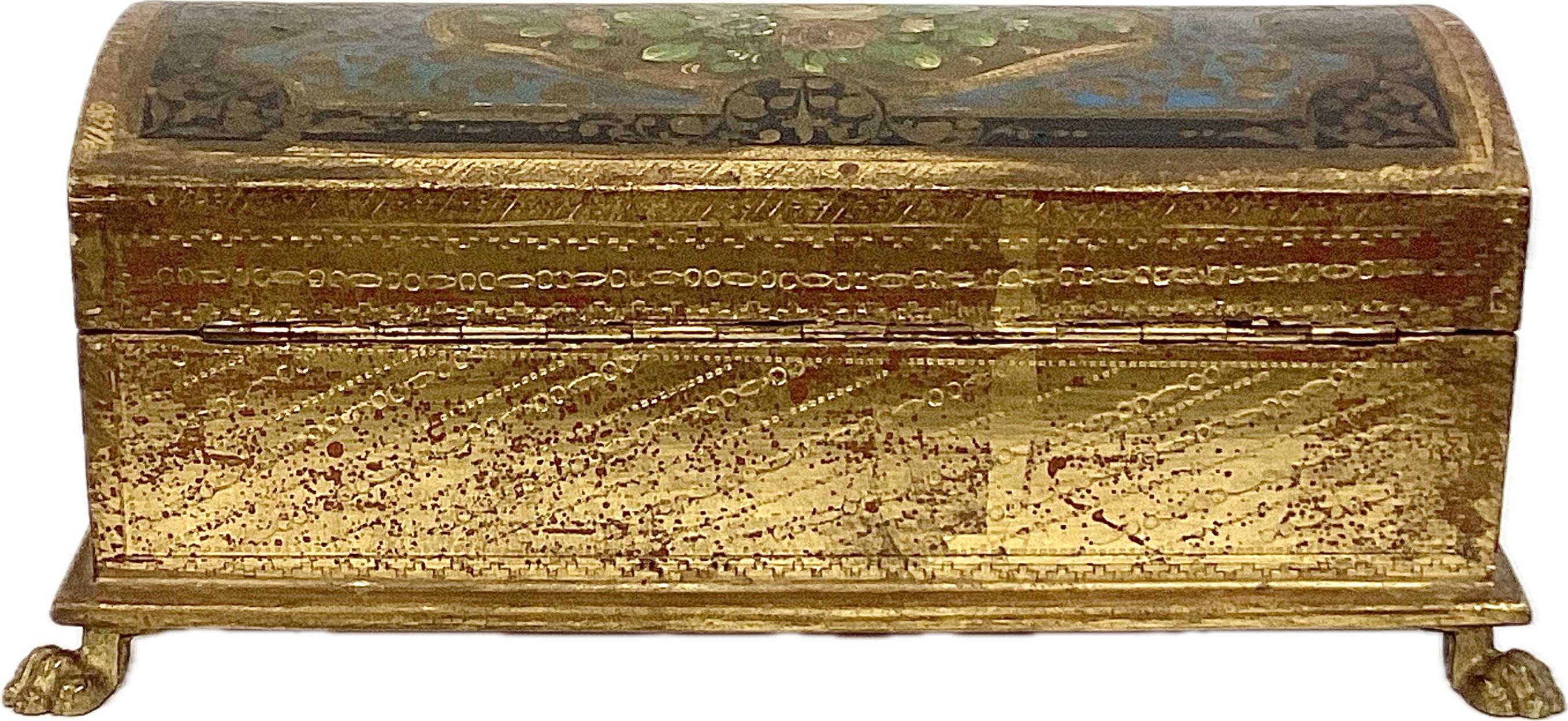 Caja de baratijas florentina del siglo XX pintada a mano con patas doradas. La caja es de madera dorada y está adornada con flores y fauna pintadas a mano meticulosamente con ricos colores azul, verde, negro y dorado. El interior es de madera maciza