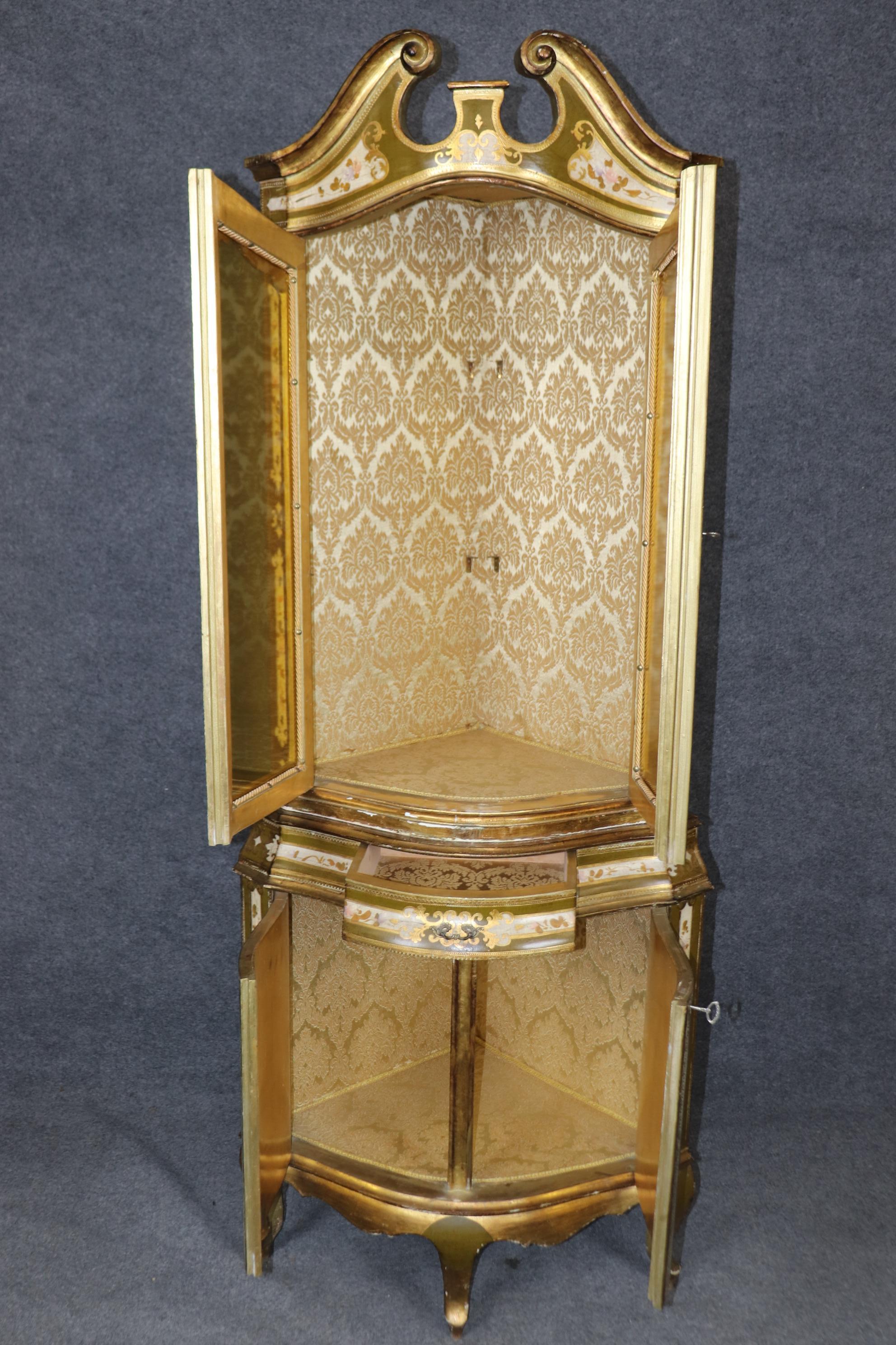 Si tratta di una rara forma di mobile angolare di produzione italiana o fiorentina e presenta splendide decorazioni a vernice e i tipici dettagli in foglia d'oro di Florentine. Le porte in vetro sono colorate di ambra, non trasparenti, in modo da