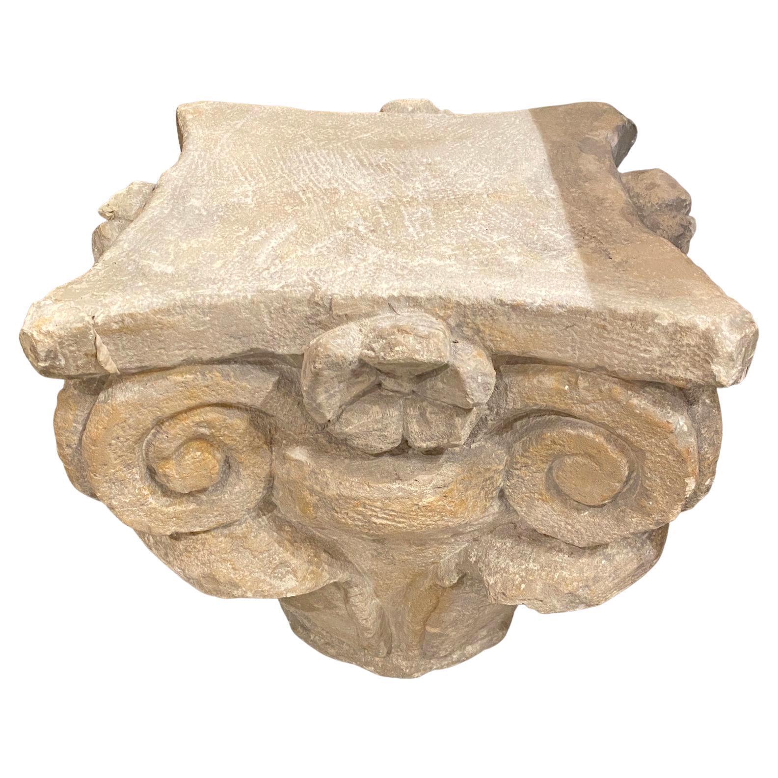 A hand carved baroque style stone capital. Design features scrolls and flowers.