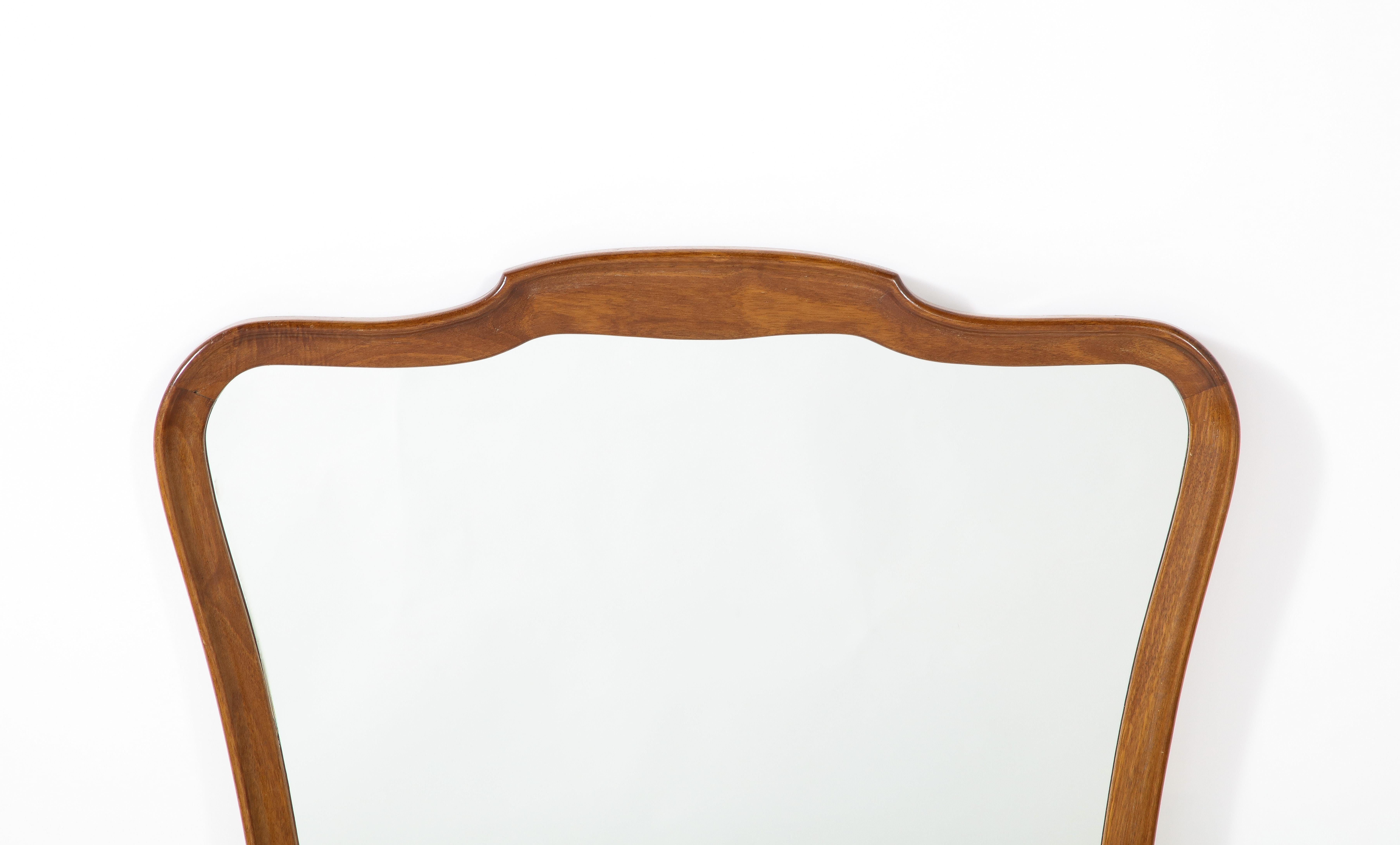 An elegantly shaped walnut mirror. Classical and refined the warmth and richness of the walnut highlight the simple and refined frame. 
Florence, Italy, circa 1940.
Size: 35 1/2