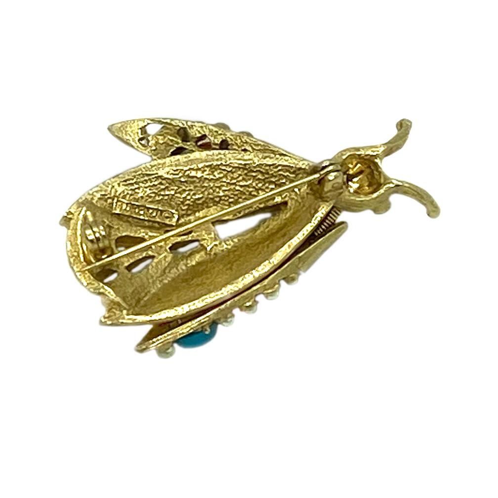This is a 1950s Florenza bug pin/brooch with trembler wings. It's colorful wings are decorated with faux corals, turquoises and pears. This small gold-tone bug will come alive on your shouder with its trembling wings.

Florenza (Dan Kasoff, Inc.
