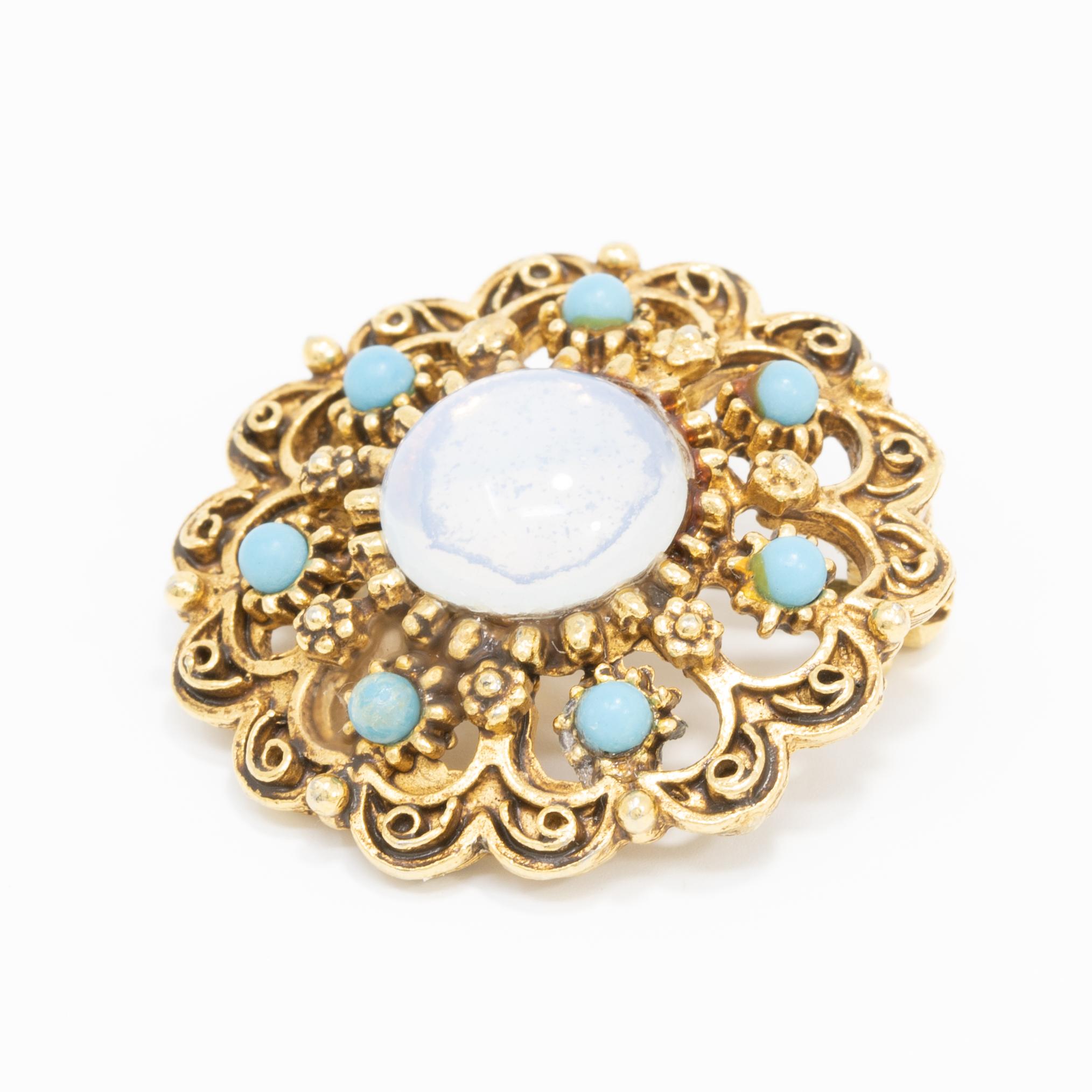 A vintage, Victorian-style cameo. A centerpiece moon-glow cabochon is set in a gold-plated decorative setting, accented with turquoise-colored beads.

Gold plated.

Marks / Hallmarks: Florenza