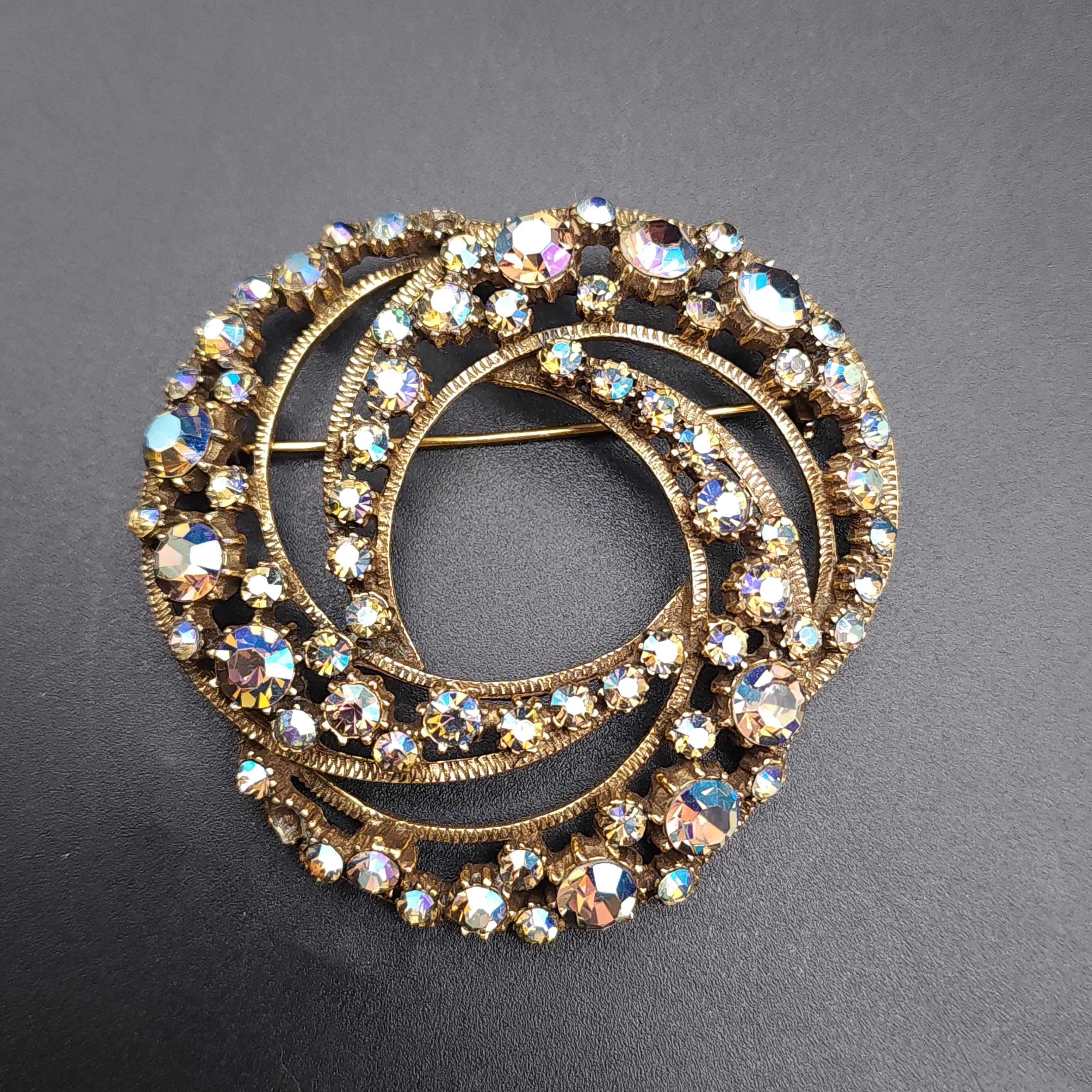 Brooch size: 2.5 inches
Earring size: 1.25 inches each

Discover the enchanting allure of the Florenza demi parure, a stunning set that includes clip-on earrings and a matching pin. Each piece is adorned with icy blue aurora borealis crystals,