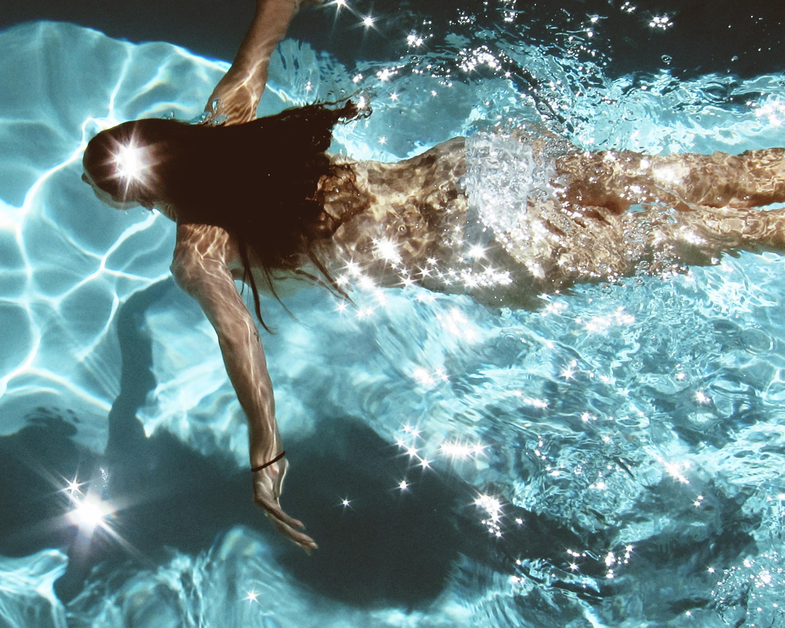 Florian Innerkofler Color Photograph - La Piscina, Capri - Naked woman in pool swimming underwater