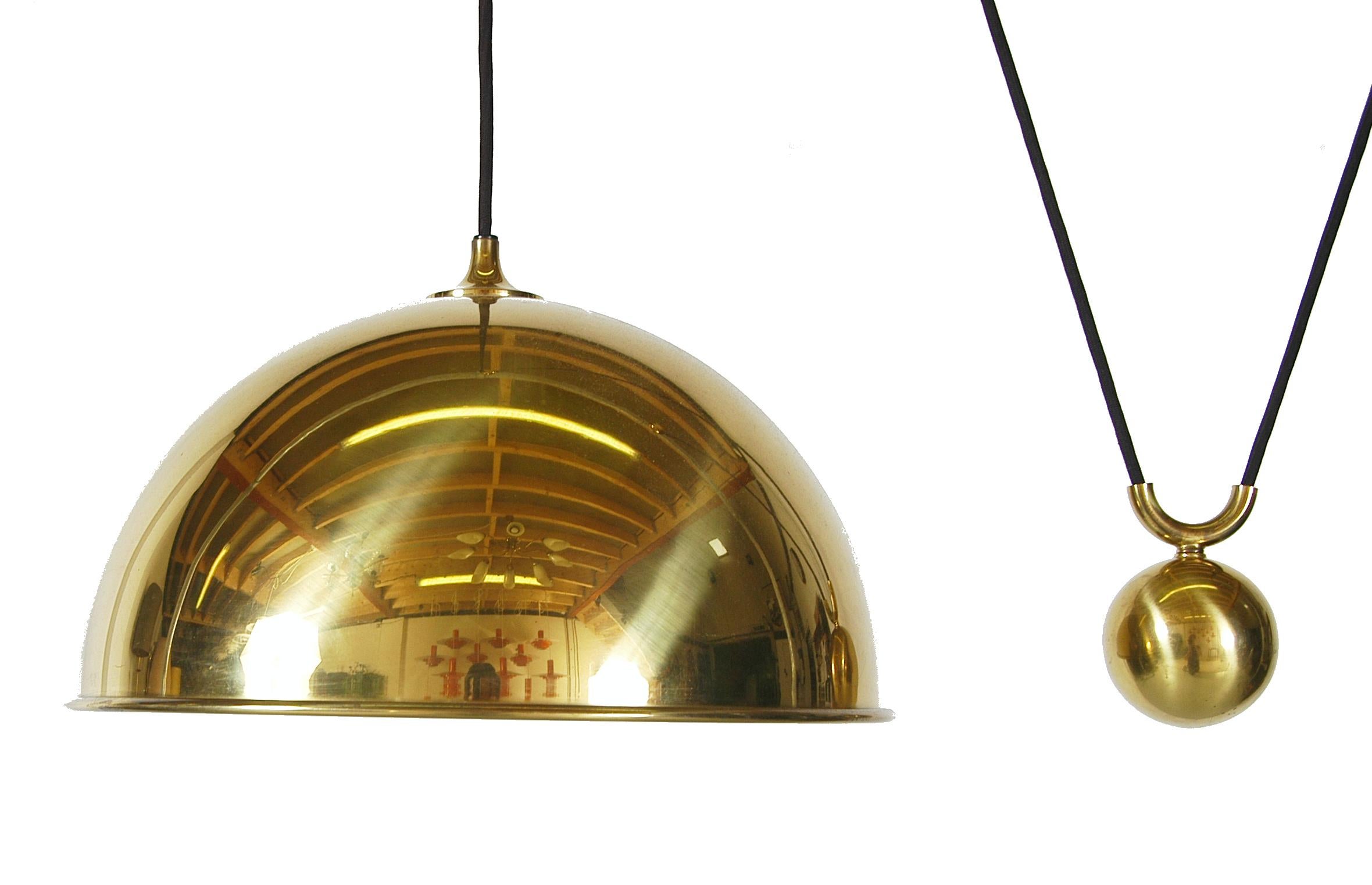 A height adjustable Florian Schultz Posa pendant light dating from circa 1970-1979 with counterweight in solid polished brass.
The brass has a rich and warm tone and the inner side of the light shade has a matte finish.
The height is adjustable in