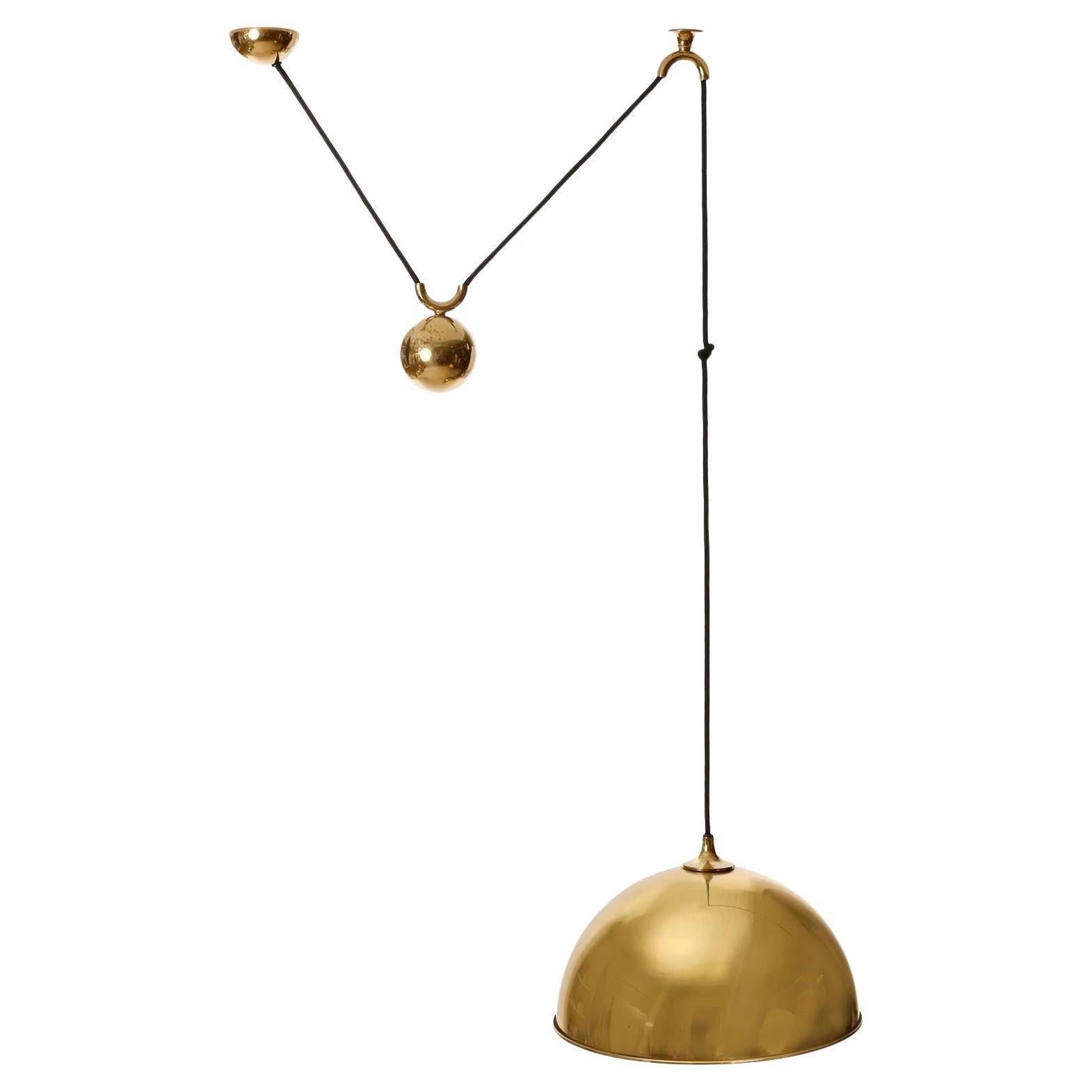 Lampada a sospensione regolabile in altezza di Florian Schulz, Germania, prodotta a metà del secolo scorso, circa 1970 (fine anni '60 o inizio anni '70).
L'apparecchio è realizzato in ottone massiccio e lucido, con una superficie invecchiata in una