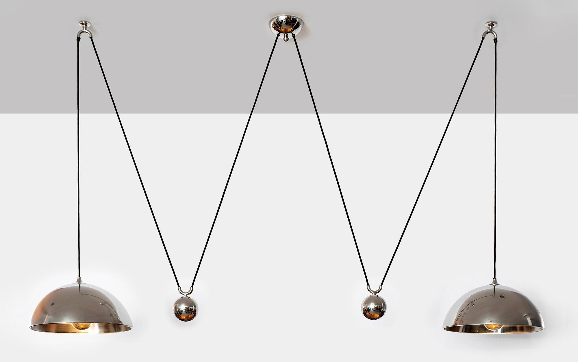 Double counterbalance pendant by Florian Schulz. Two nickel pendants suspended, each with their own nickel ball counter balance pulley system. One centre canopy supports both pendants. Each light is adjustable in height without effecting the other.