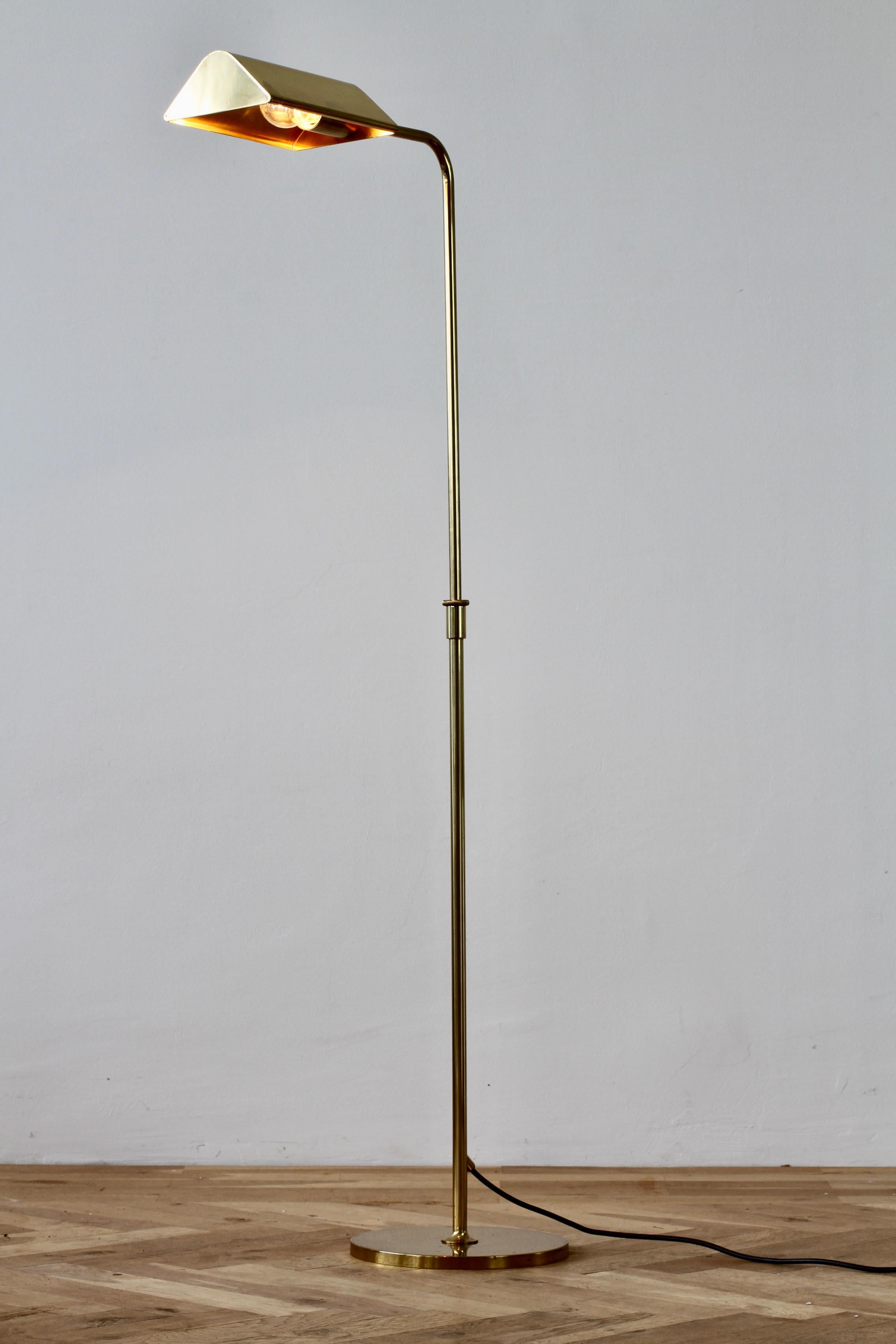 Mid-Century Modern vintage German made adjustable reading light or floor lamp designed by Florian Schulz circa late 1970s - early 1980s. Featuring polished brass (now with age related patina) and height adjustable as is the round brass shade making