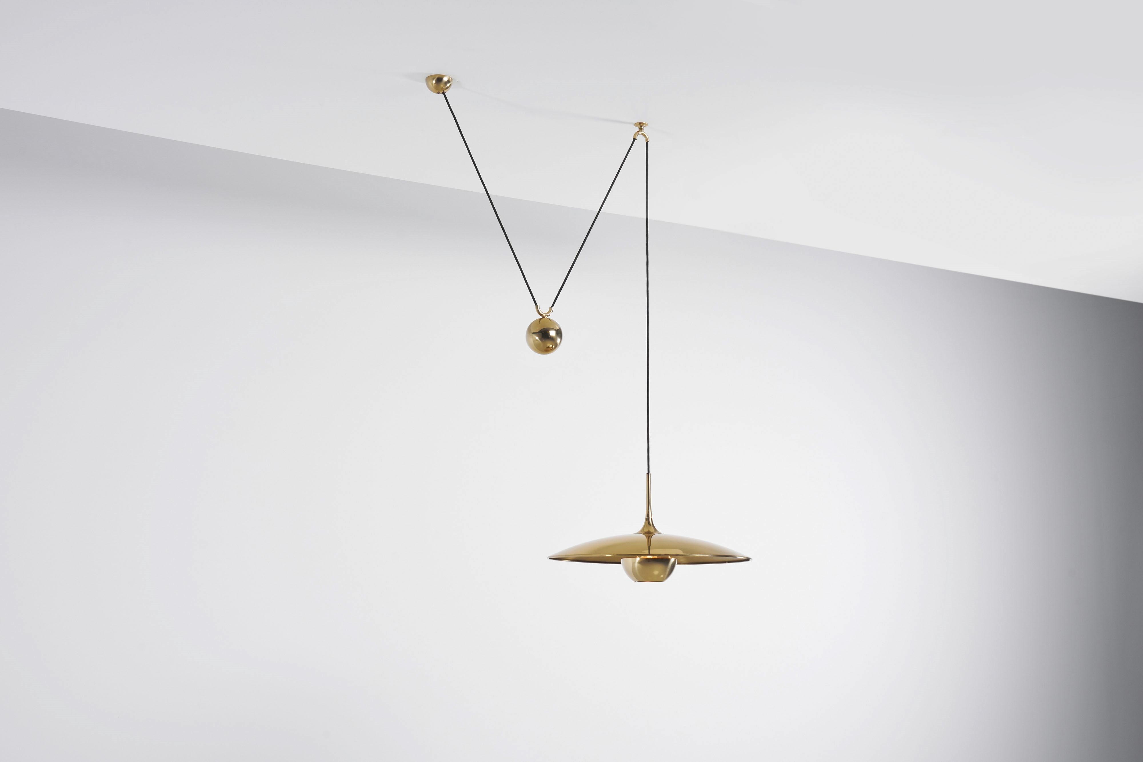 Very nice and versatile adjustable ceiling pendant lamp model Onos 55 designed and manufactured by Florian Schulz, Germany 1970. This lamp is made of polished brass and has a heavy weighted round ball to adjust the height on this, you can also