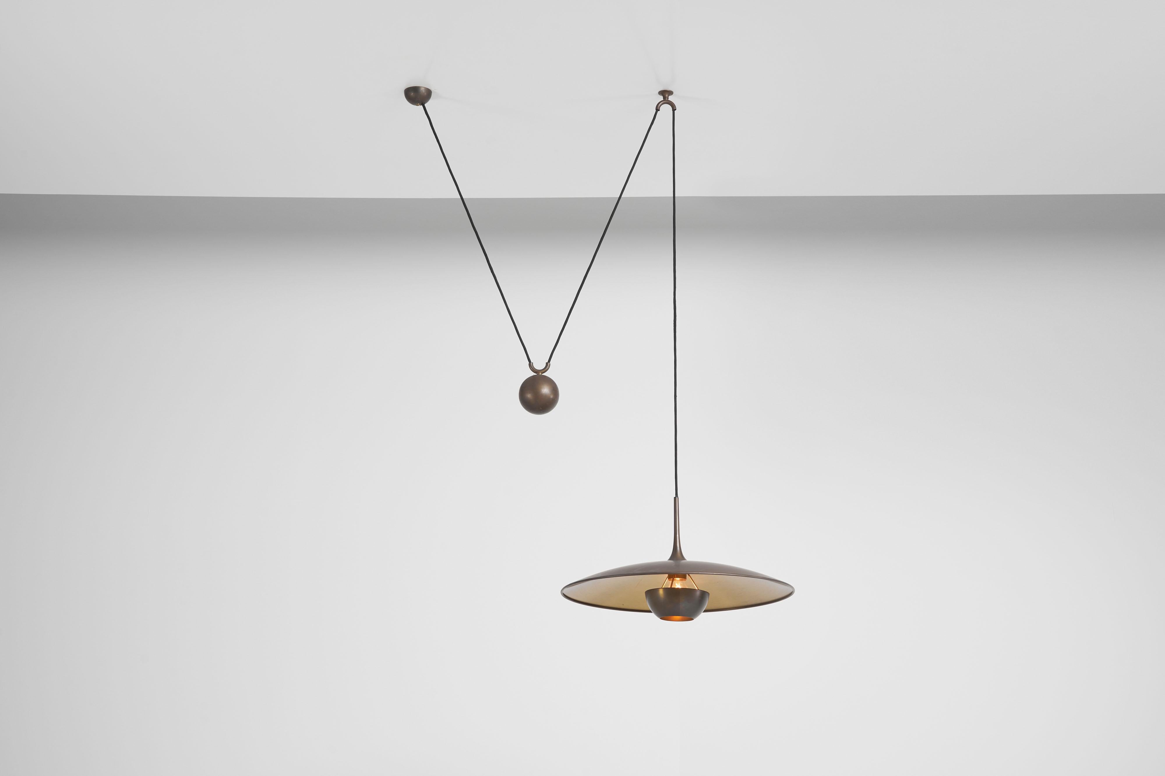 Stunning Onos 55 pendant lamp designed by Florian Schulz manufactured in Germany in 1970. Made from beautiful patinated brass, the lamp features a weighty spherical ball that serves a dual purpose: adjusting the lamp's height and width to your