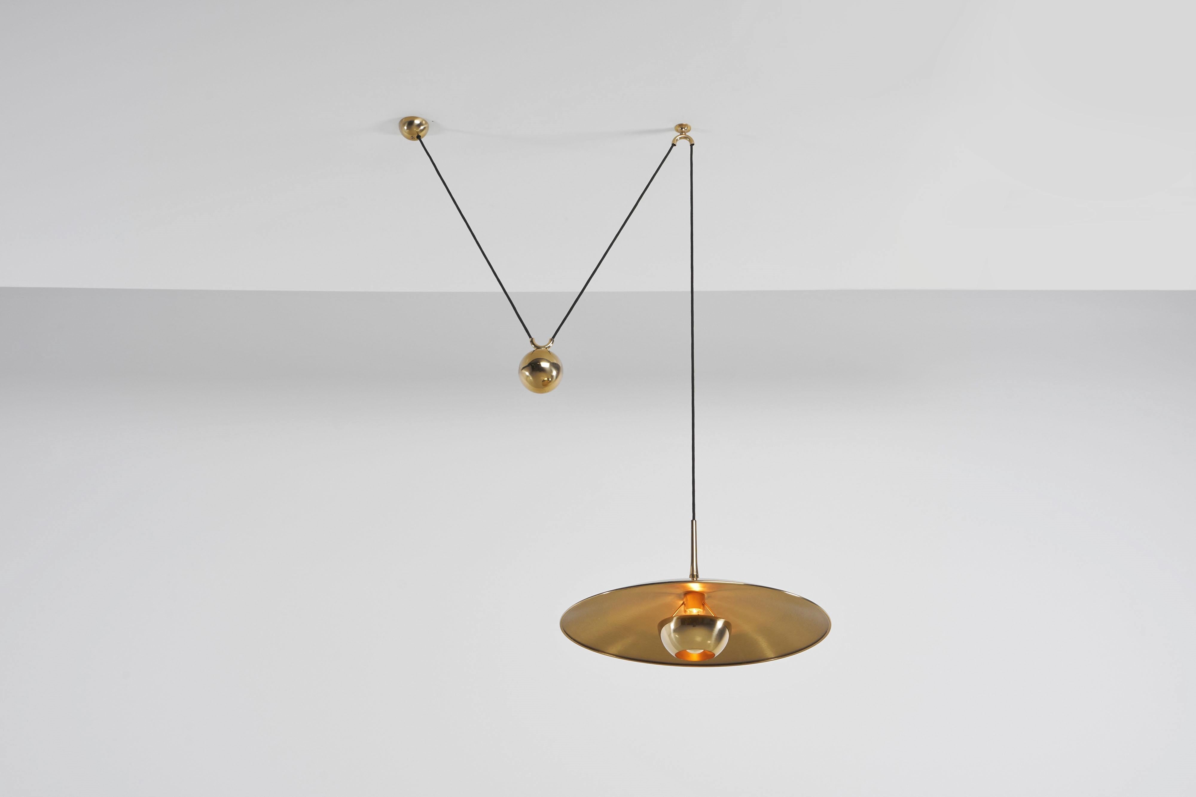 Very nice and versatile adjustable ceiling pendant lamp model Onos 55 designed and manufactured by Florian Schulz, Germany 1970. This lamp is made of polished brass and has a heavy weighted round ball to adjust the height on this, you can also