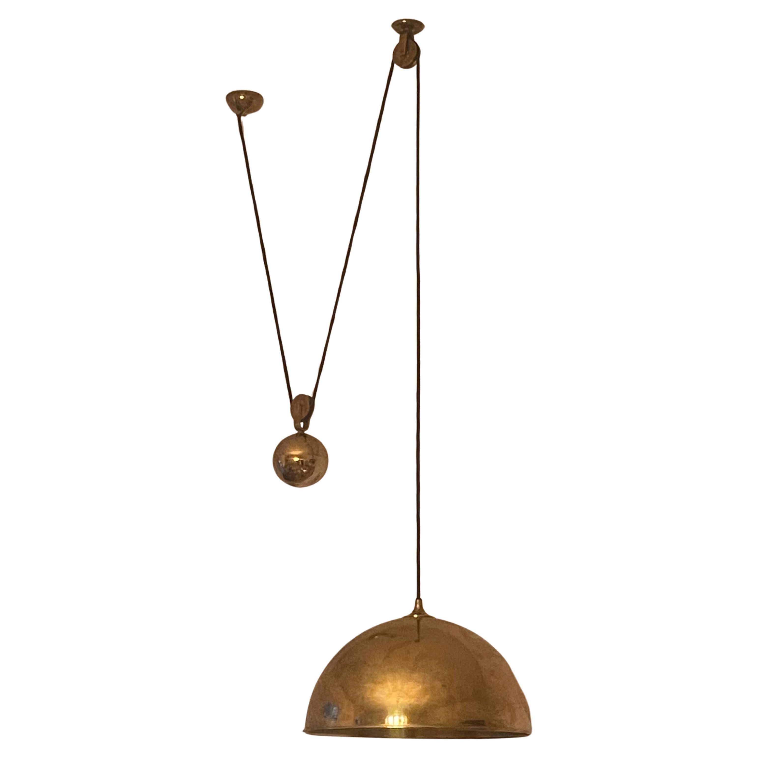 A large polished brass counterbalance pendant with brass ball counter balance pulley system by Florian Schulz, circa 1970s.
The light fixture is adjustable in height. The item is in a great condition and has a delicate patination.
Socket: two E27 or