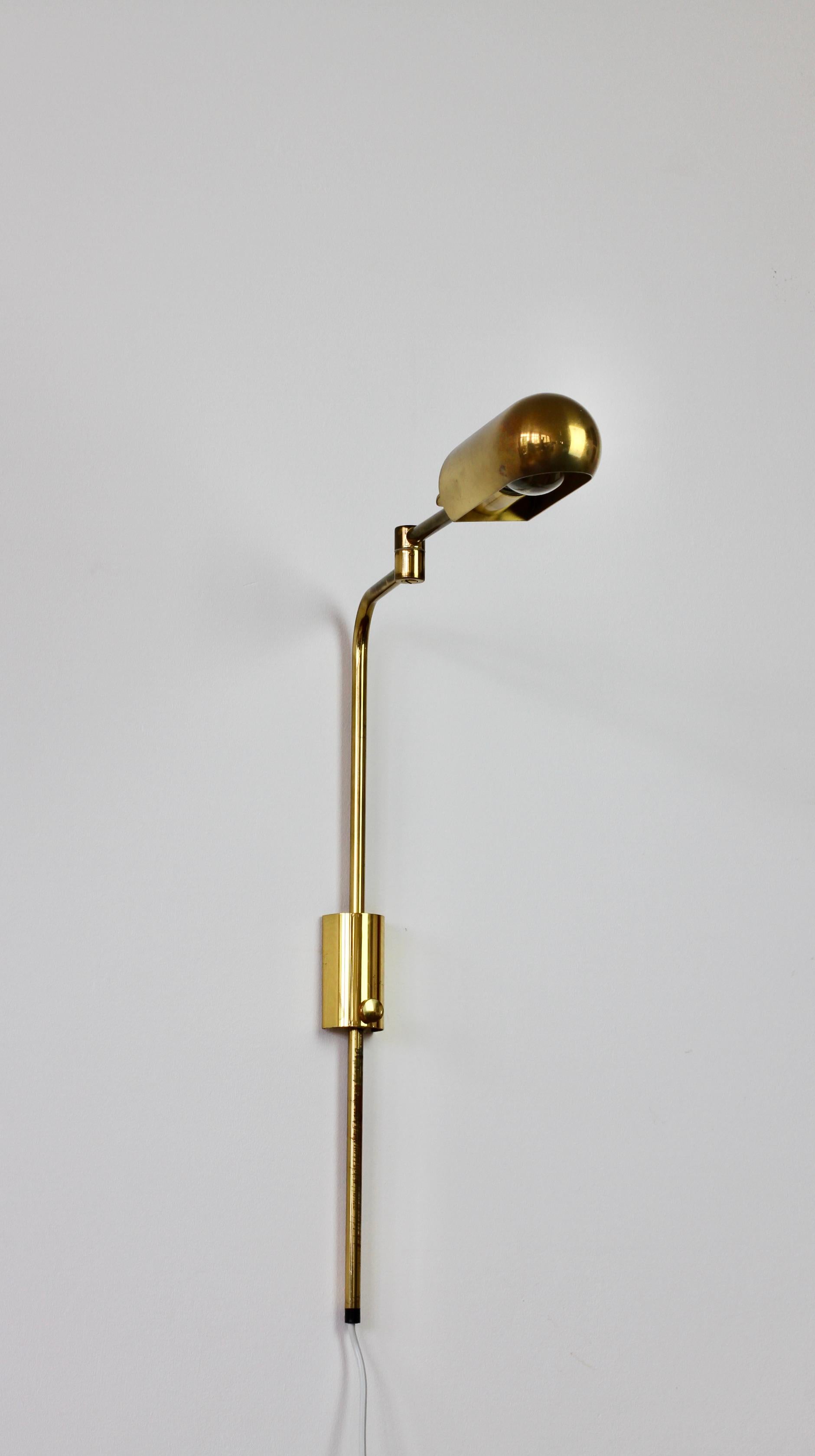 Rare Mid-Century Modern vintage German adjustable wall mounted reading lamp, light or sconce by Florian Schulz circa late 1970s -early 1980s. Featuring polished brass (now with age related patina) and fully adjustable curved. and rounded lampshade