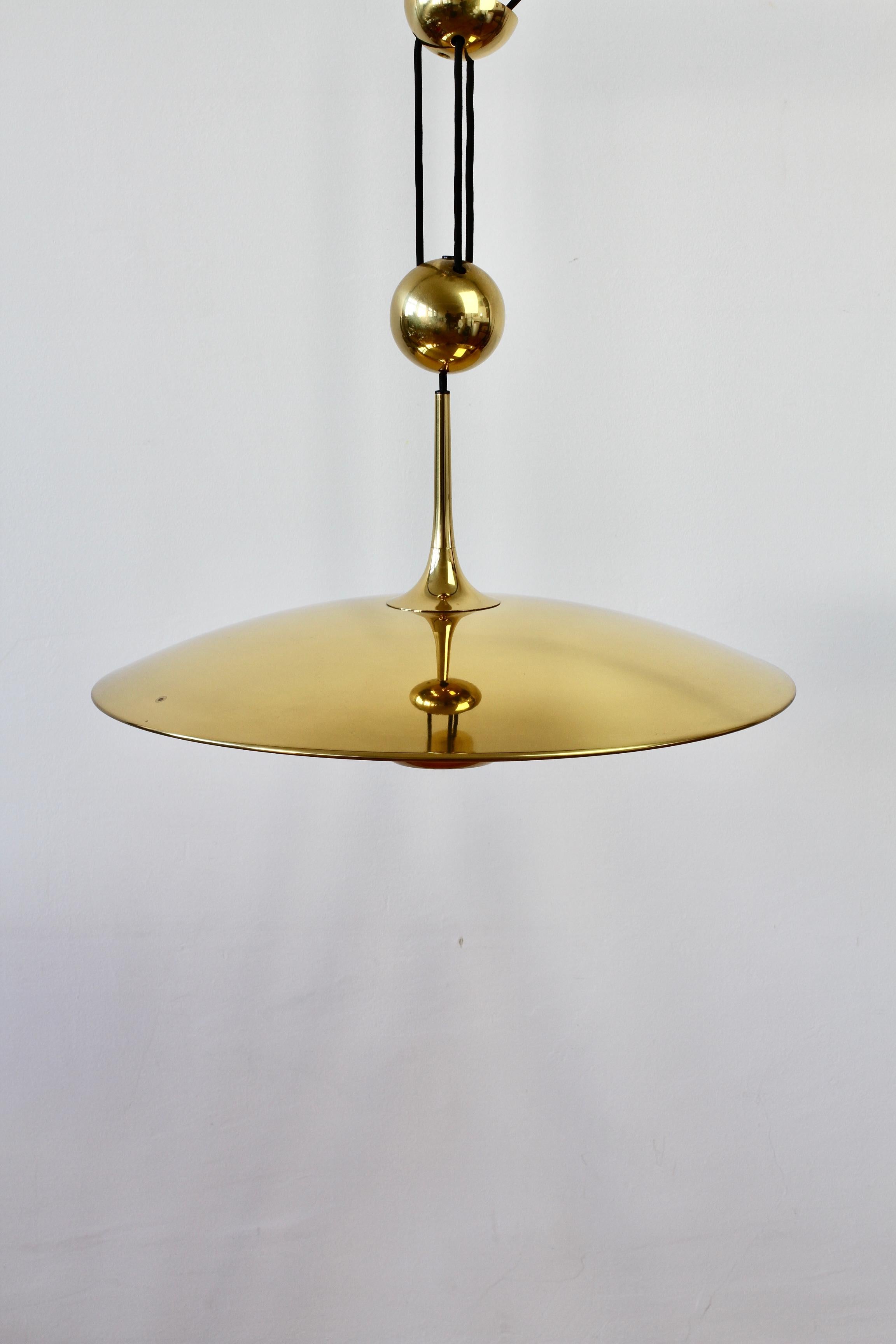 Stunning and elegant Mid-Century Modern vintage German made large polished brass adjustable counterweight hanging pendant light or lamp model 'ONOS 55' designed by Florian Schulz circa early 1970s. Featuring polished brass (now with minimal age