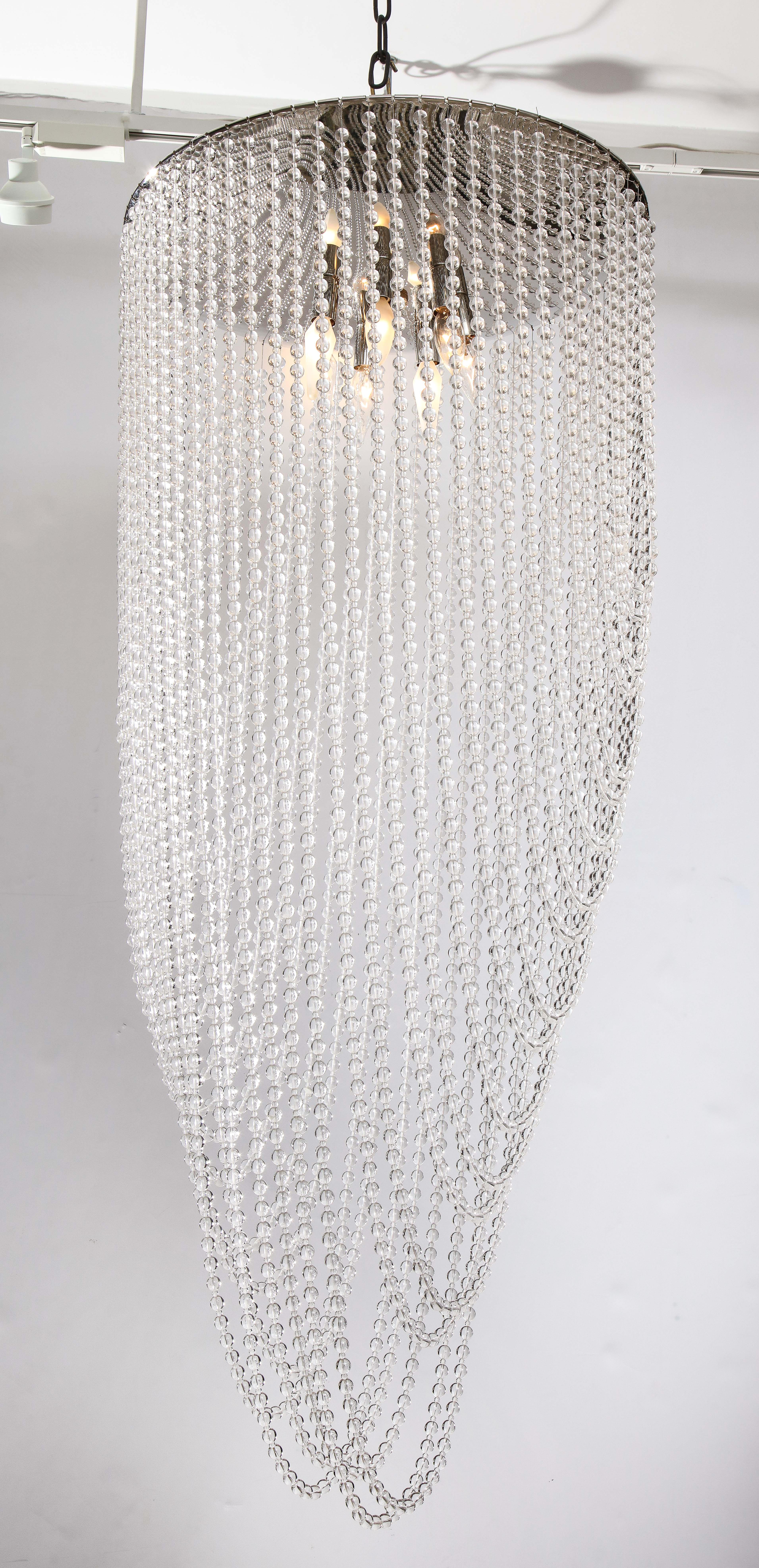 A fantastic Hollywood Regency beaded chandelier drapes down with chains of beaded crystals by 
Florian Schulz.