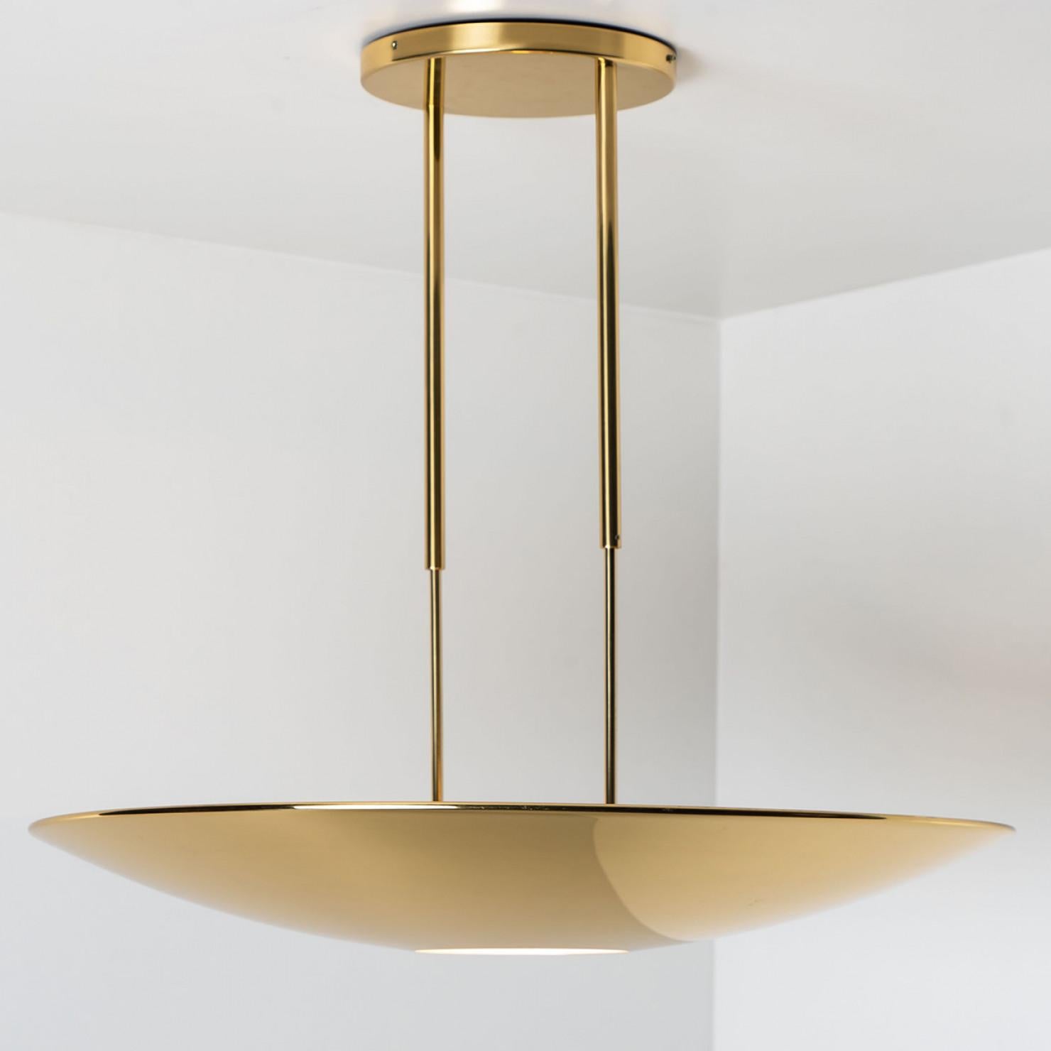 High quality brass pendant lamp or ceiling fixture by Florian Schulz. The light has an opening at the bottom for a round diffuser out of glass. It is 80 cm in diameter and radiates a direct and an indirect lighting.
The light is adjustable in height