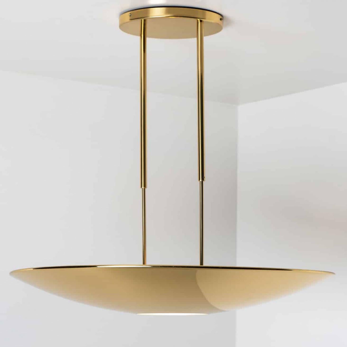 Lámpara colgante o plafón de latón de alta calidad de Florian Schulz. La luz tiene una abertura en la parte inferior para un difusor redondo de cristal. Tiene 80 cm de diámetro e irradia una iluminación directa y otra indirecta.
La luz es regulable