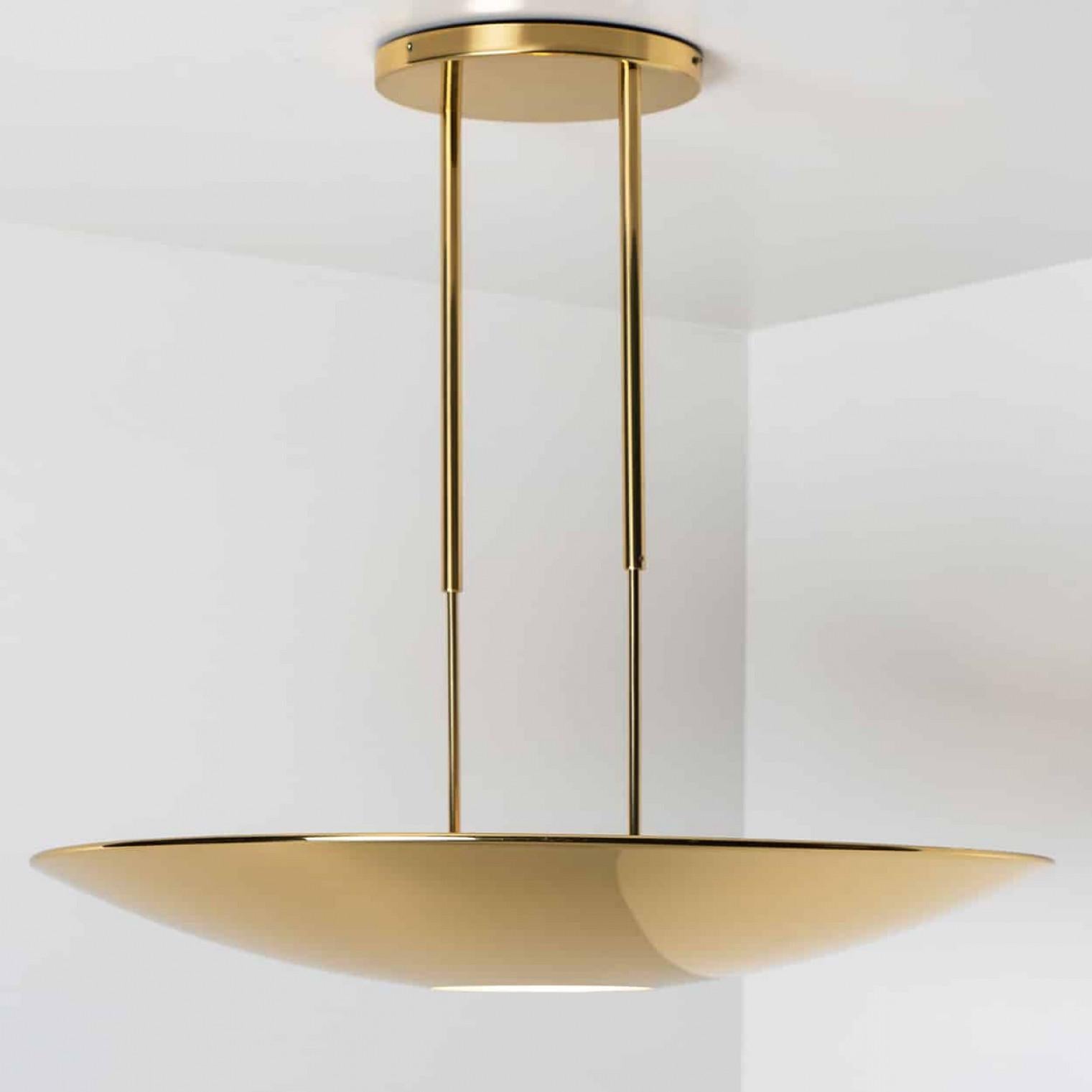 Lampada a sospensione o plafoniera in ottone di alta qualità di Florian Schulz. La lampada ha un'apertura sul fondo per un diffusore rotondo in vetro. Ha un diametro di 80 cm e irradia un'illuminazione diretta e indiretta.
La luce è regolabile in