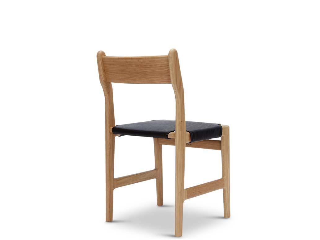 Floriano Leather Dining Chair. Inspired by Scandinavian mid century design, the Floriano Caned Dining Chair has a wooden frame that contracts and expands to highlight a subtly curved back. Available in handwoven cane or supple leather, the chair