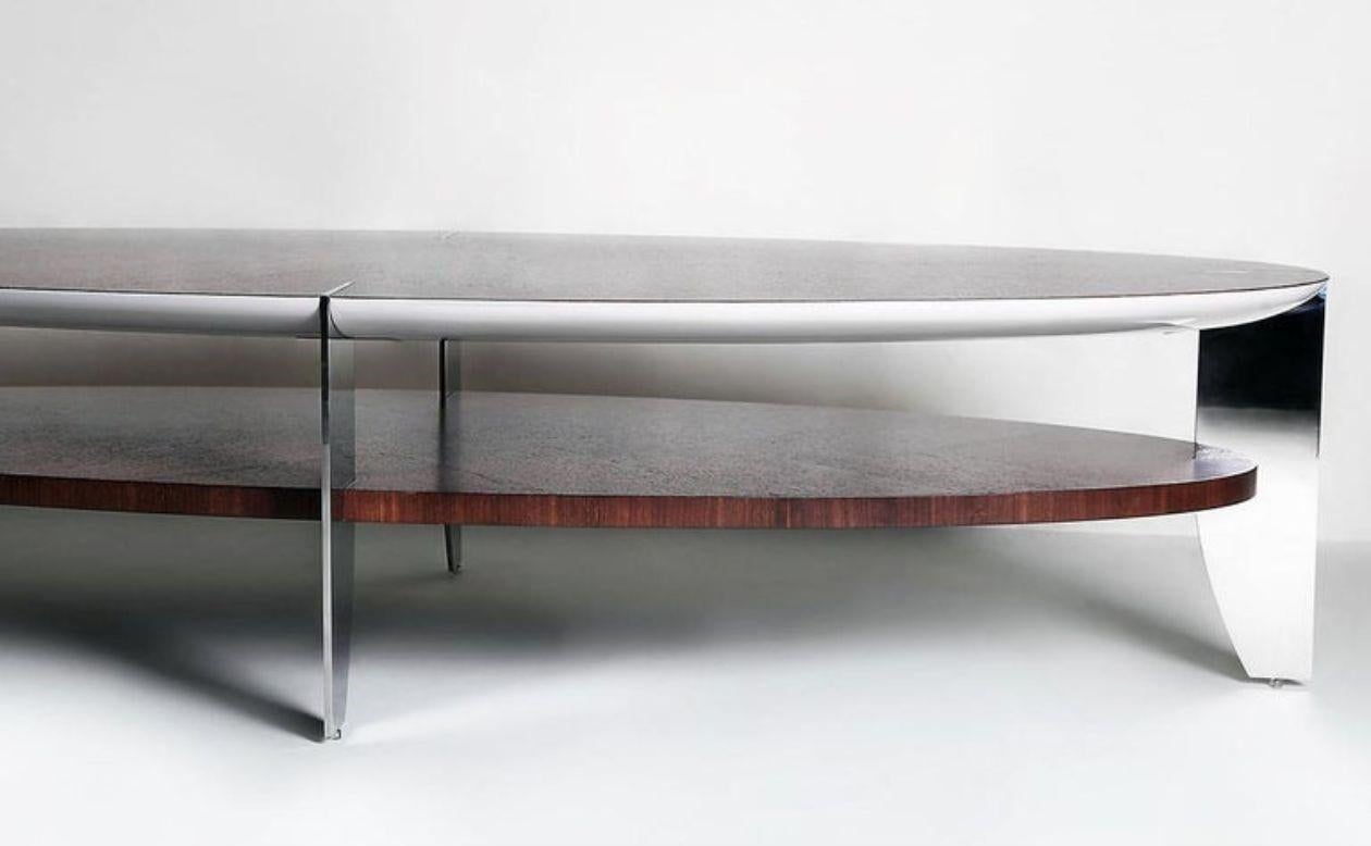 An encounter between RIVA and Eclipse tables, this boat shaped table is carefully crafted into an eclipse of two tops overlapping one another.
It is made from Rosewood and grey shell 100% gloss with polished stainless steel legs.