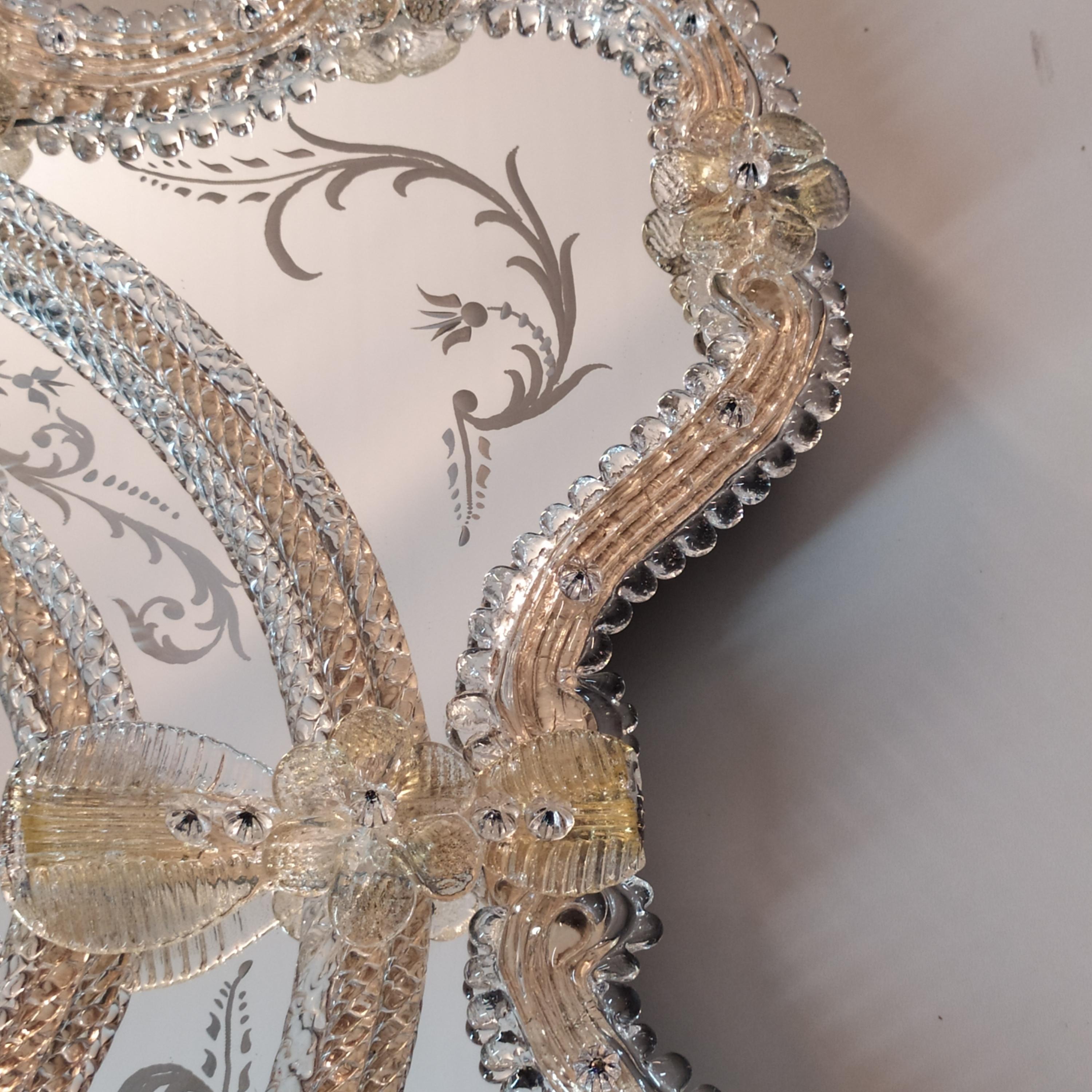 “Florida” Venetian Murano Glass Mirror, made by the expert hands of Murano Masters, with frame composed of Murano crystal reeds and curls on a gold background, the engravings that adorn this luxurious mirror are completely handmade, and the trim
