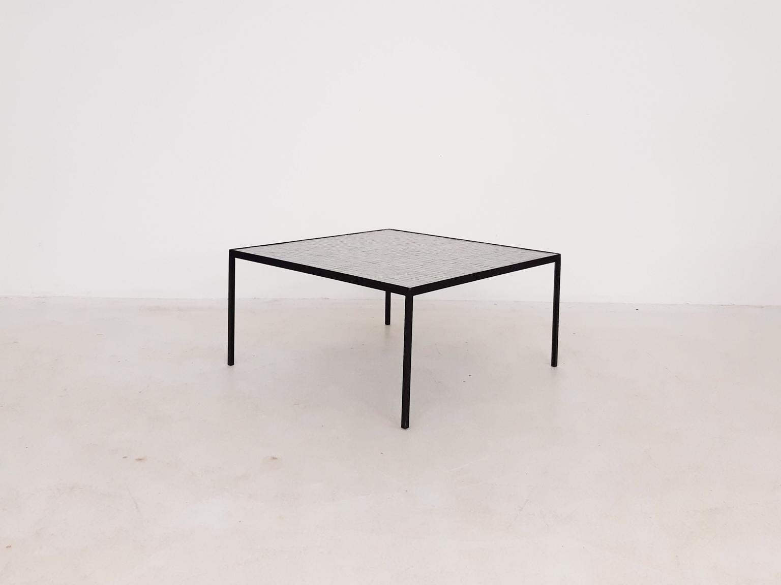Stunning minimalistic Dutch midcentury coffee table with a black metal frame and a beautiful white mosaic top, which is made by hand.

It has many resemblances with the coffee table by the Dutch Floris Fiedeldij for Artimeta. The sizes and shapes
