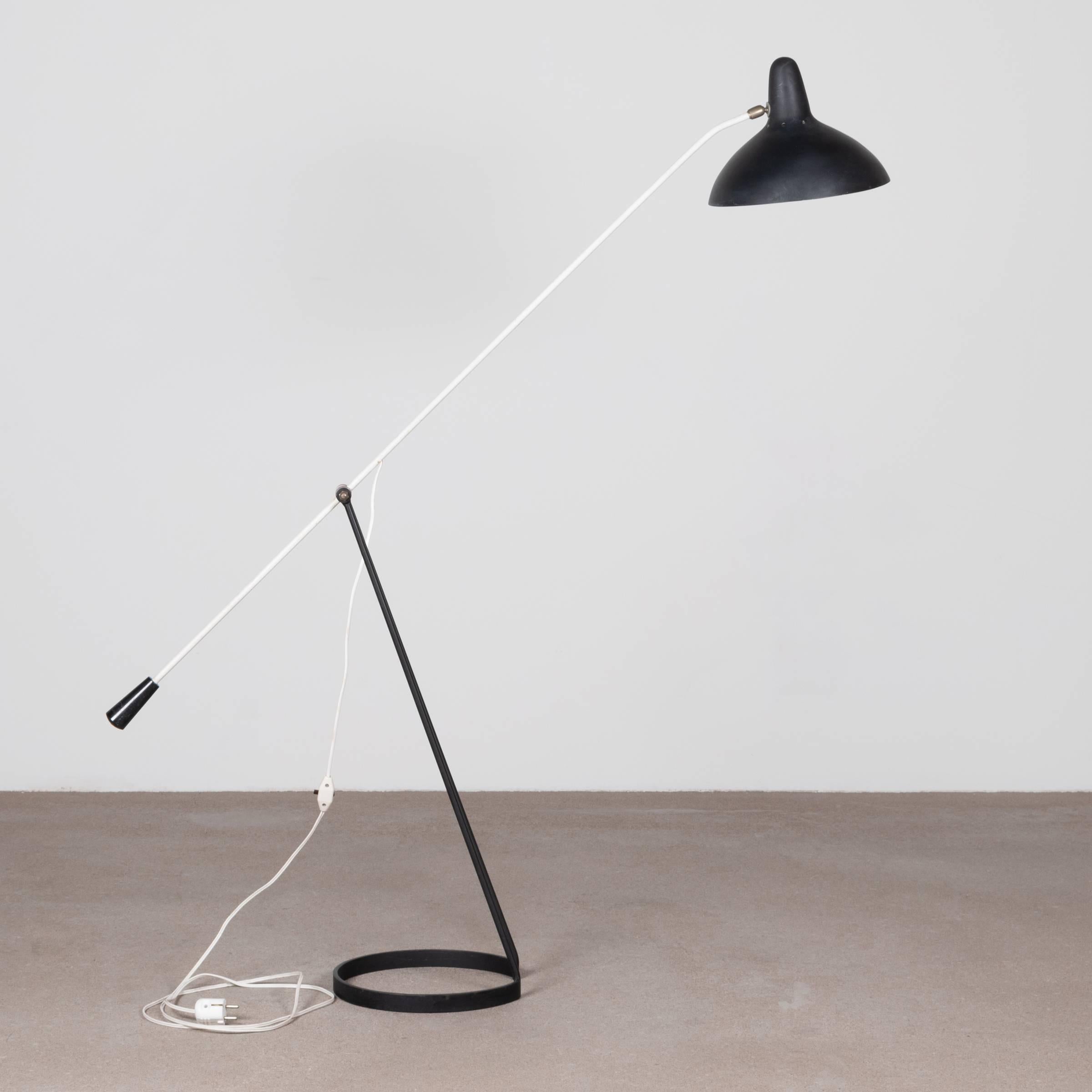 Rare and collectable elegant floor lamp by Floris Fiedeldij for Artimeta (Netherlands). Black and white enameled steel base with pendulum arm and brass details. Very good original working condition with beautiful patina.