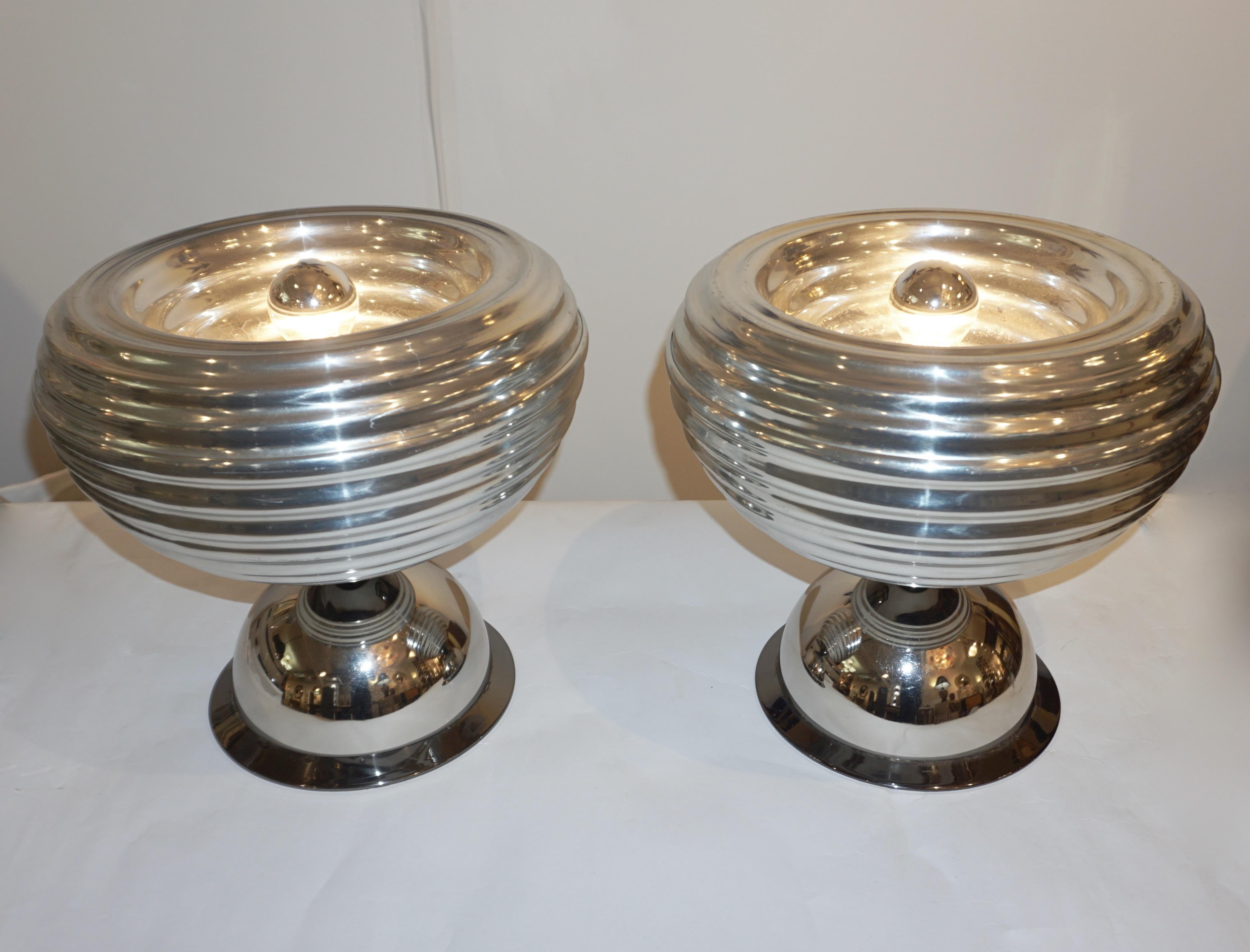 1960s rare organic pair of table lamps designed by Achille & Pier Giacomo Castiglioni for Flos, one still with manufacturer's label, in polished aluminum with a reflective shiny finish. The nicely spun bodies are raised on half round bases finished