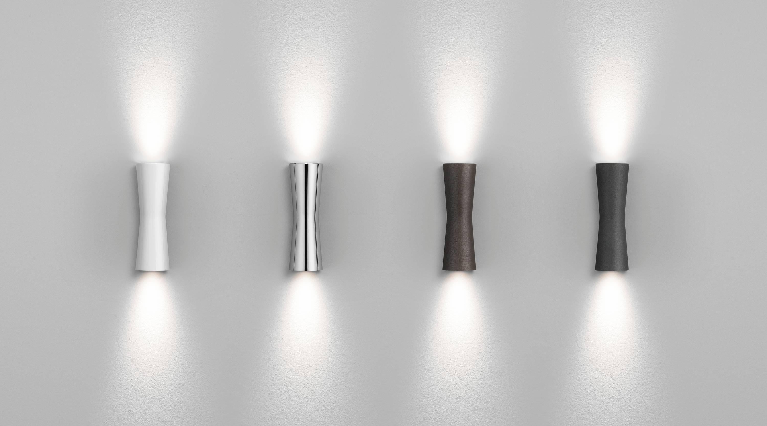 Ispirata alla forma della clessidra, la lampada Clessidra di Antonio Citterio emette una luce diffusa diretta e indiretta. Questa splendida lampada da parete ha un corpo in alluminio pressofuso con finitura a polvere e un diffusore in PMMA