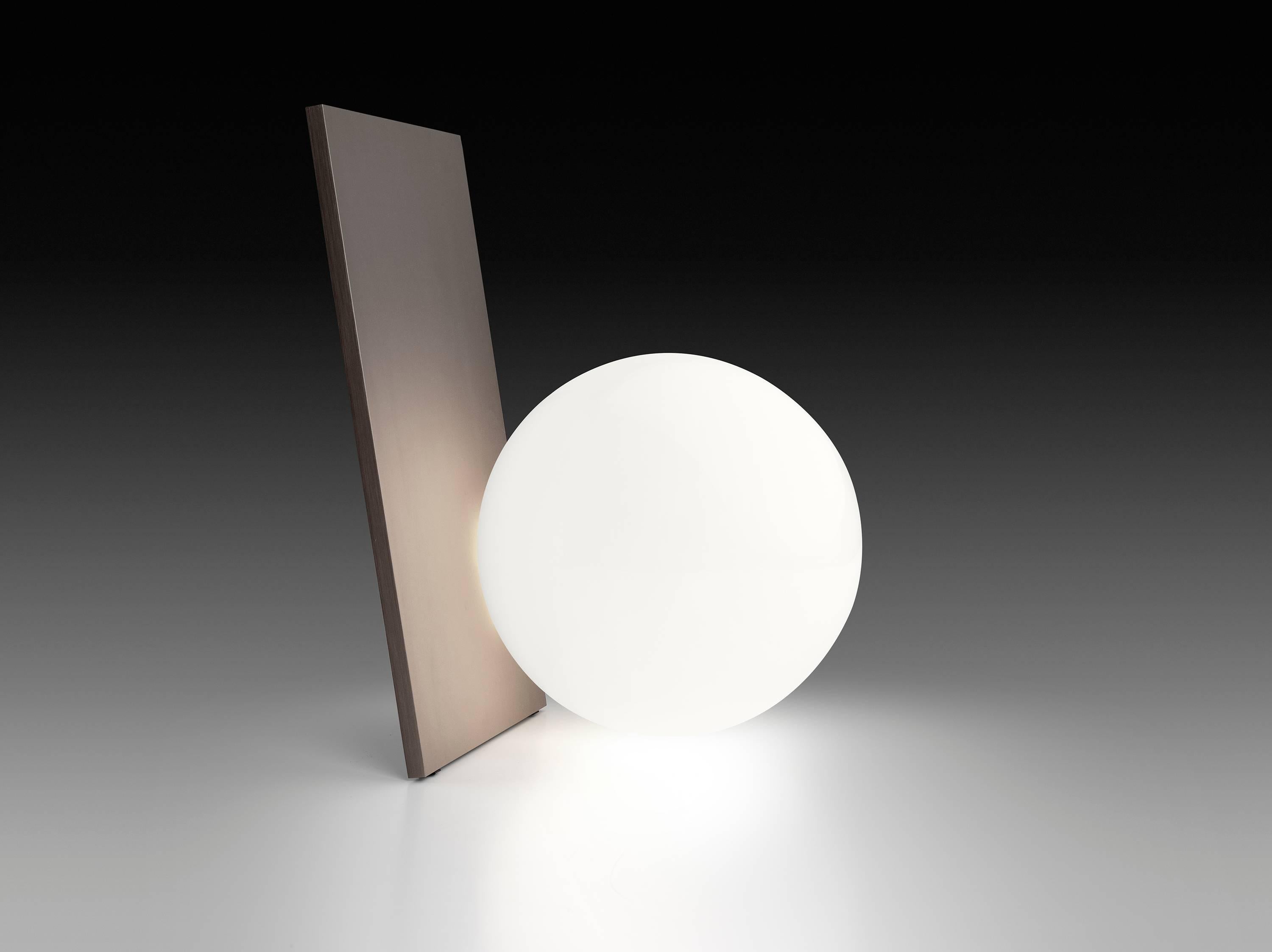 This graceful table lamp provides a soft and beautiful diffused glow through an elegant orb that is brilliantly balanced against its sleek body. It is available with a body of painted or anodized aluminum made by CNC matching. It features a