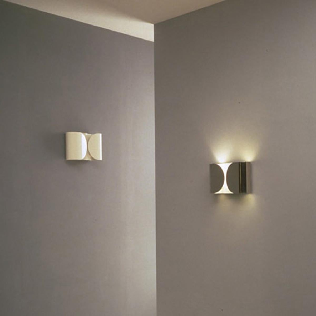 Resembling a shirt cuff, the contemporary Foglio wall lamp from design master Tobia Scarpa is a mixture of timeless and contemporary design. The lamp’s body is formed by power-painted pressed steel. The two lamp supports are injection-molded white