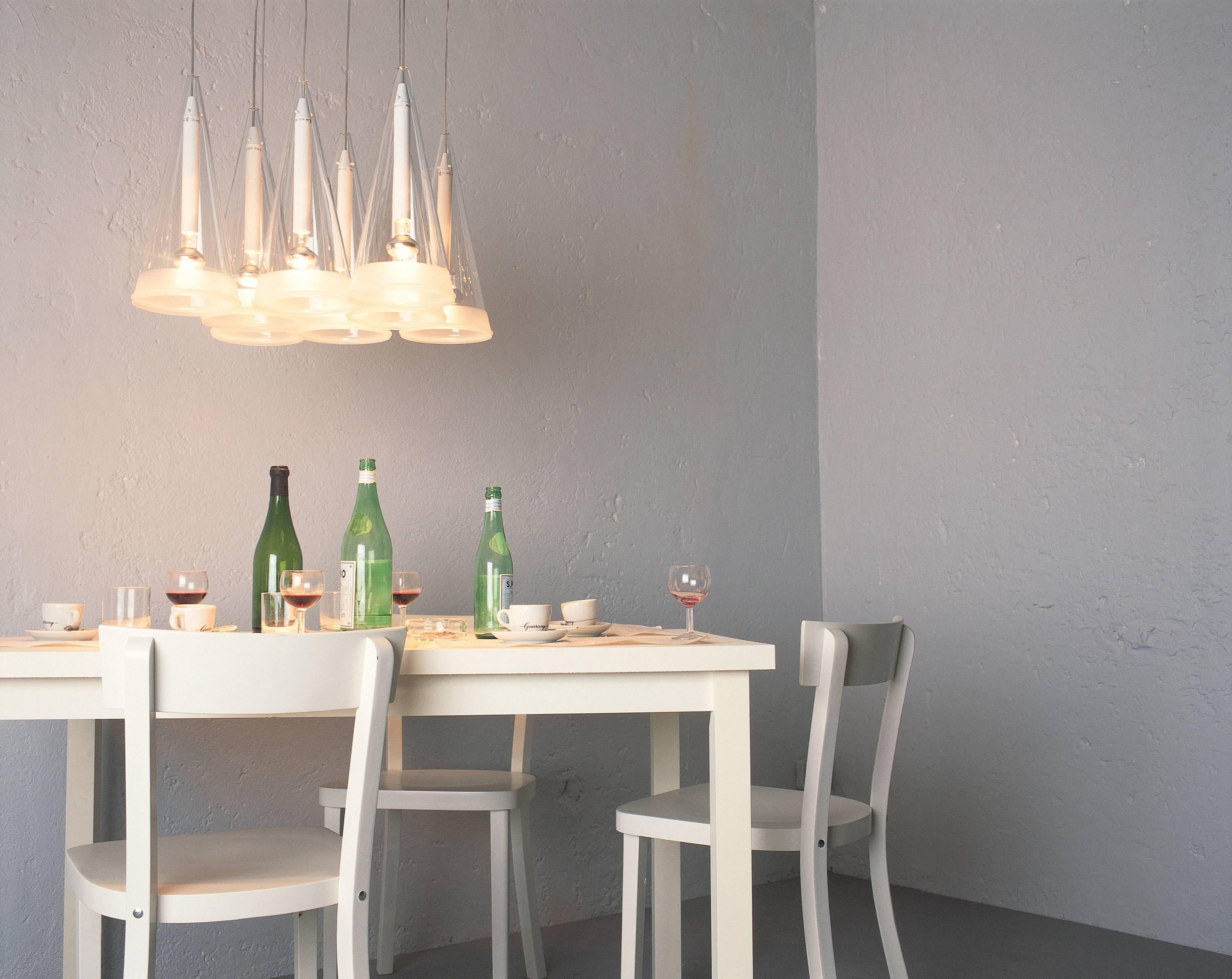 Part of the Fucsia family by Achille Castiglioni, this eight-cone configuration shares the industrial style and sophisticated finish of its kin. Offering direct and diffused light, each conical blown glass diffuser is finished with a 1.5