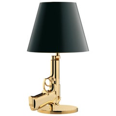 Lampe de chevet de la collection FLOS Guns en or de Philippe Starck