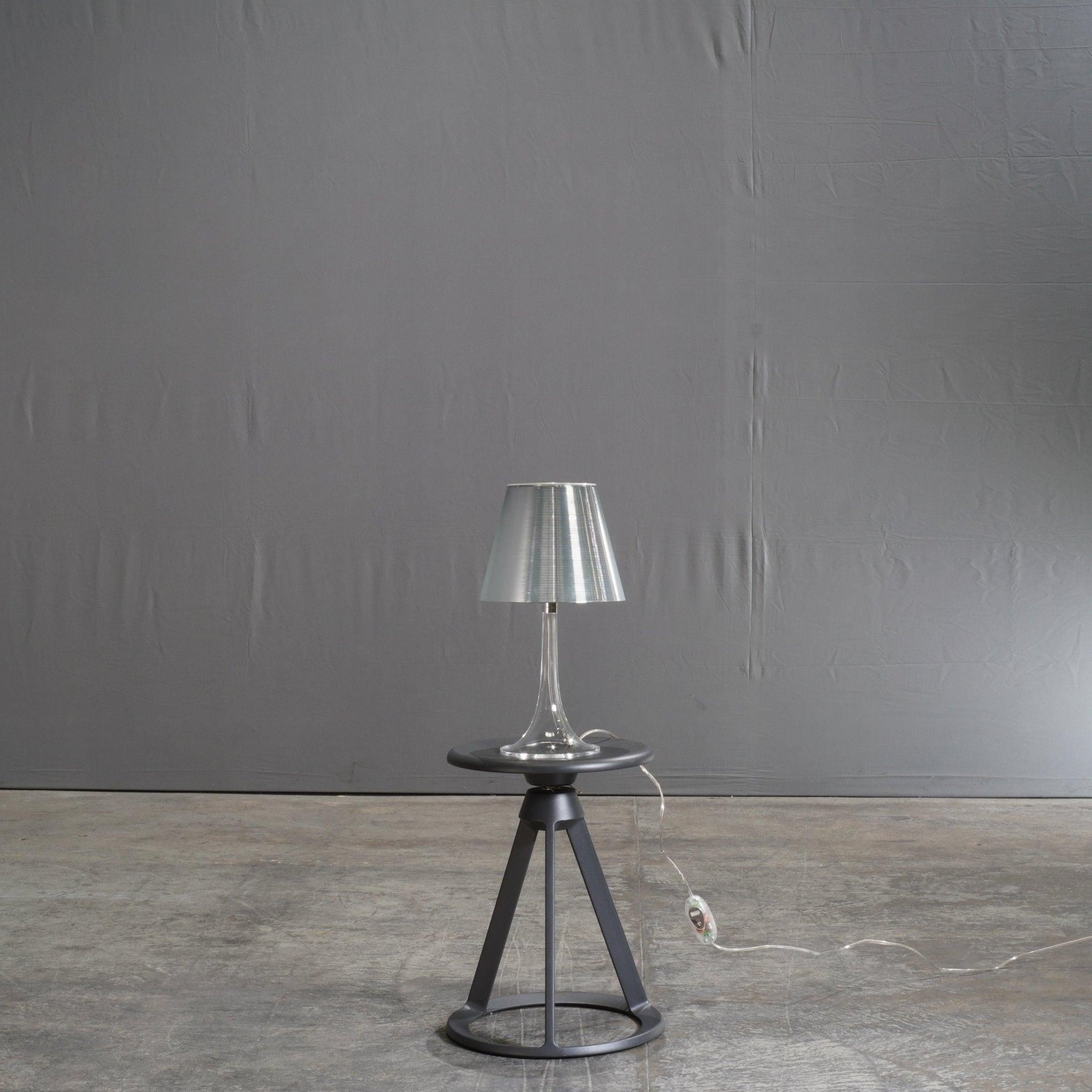 The Flos Miss K Table Lamp by Philippe Starck is a contemporary masterpiece that effortlessly combines elegance with functionality. Its iconic design features a sleek, transparent outer diffuser paired with an inner shade that emits a warm, inviting