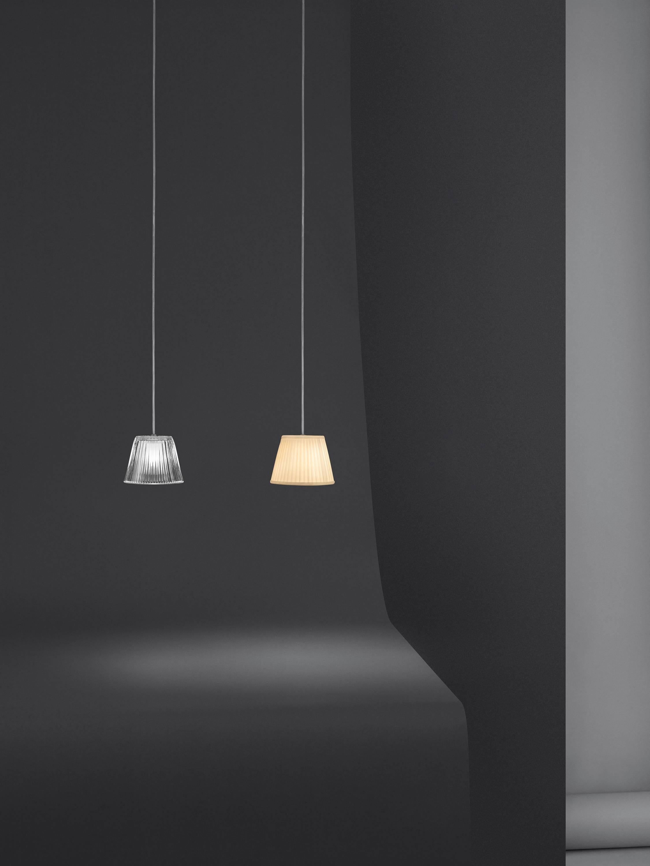 Part of the Romeo family created by industry innovator Philipe Starck, this stunning and strikingly simple pendant light provides diffused light through a plissé cloth shade and acid-etched pressed borosilicate glass internal diffuser. There is an