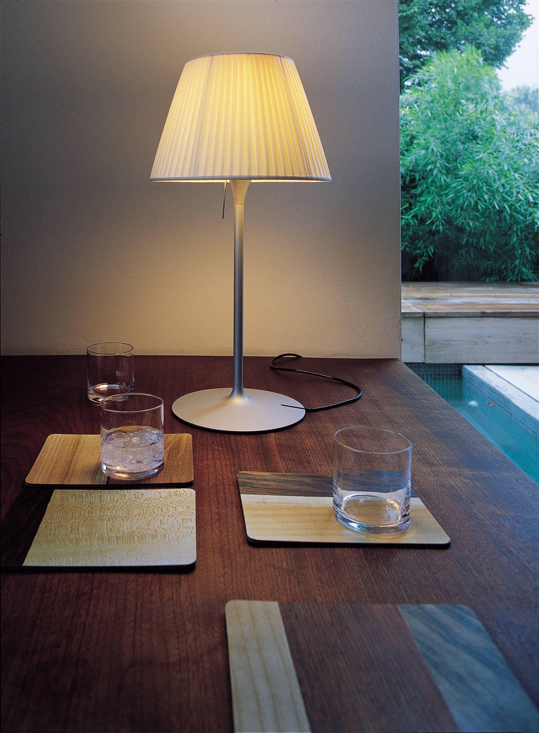 Part of the Romeo family created by industry innovator Philippe Starck, this stunning and strikingly simple table lamp provides diffused light through a plissé cloth shade and acid-etched pressed borosilicate glass internal diffuser. The steel stem