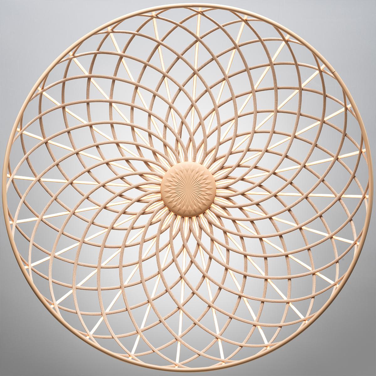 Lampada a sospensione diffusa: una combinazione di elementi luminosi e scuri disposti in una rete e formati da strutture centrali ricoperte da una sottile rete tubolare colorata intrecciata realizzata in tessuto riciclato e riciclabile prodotto in