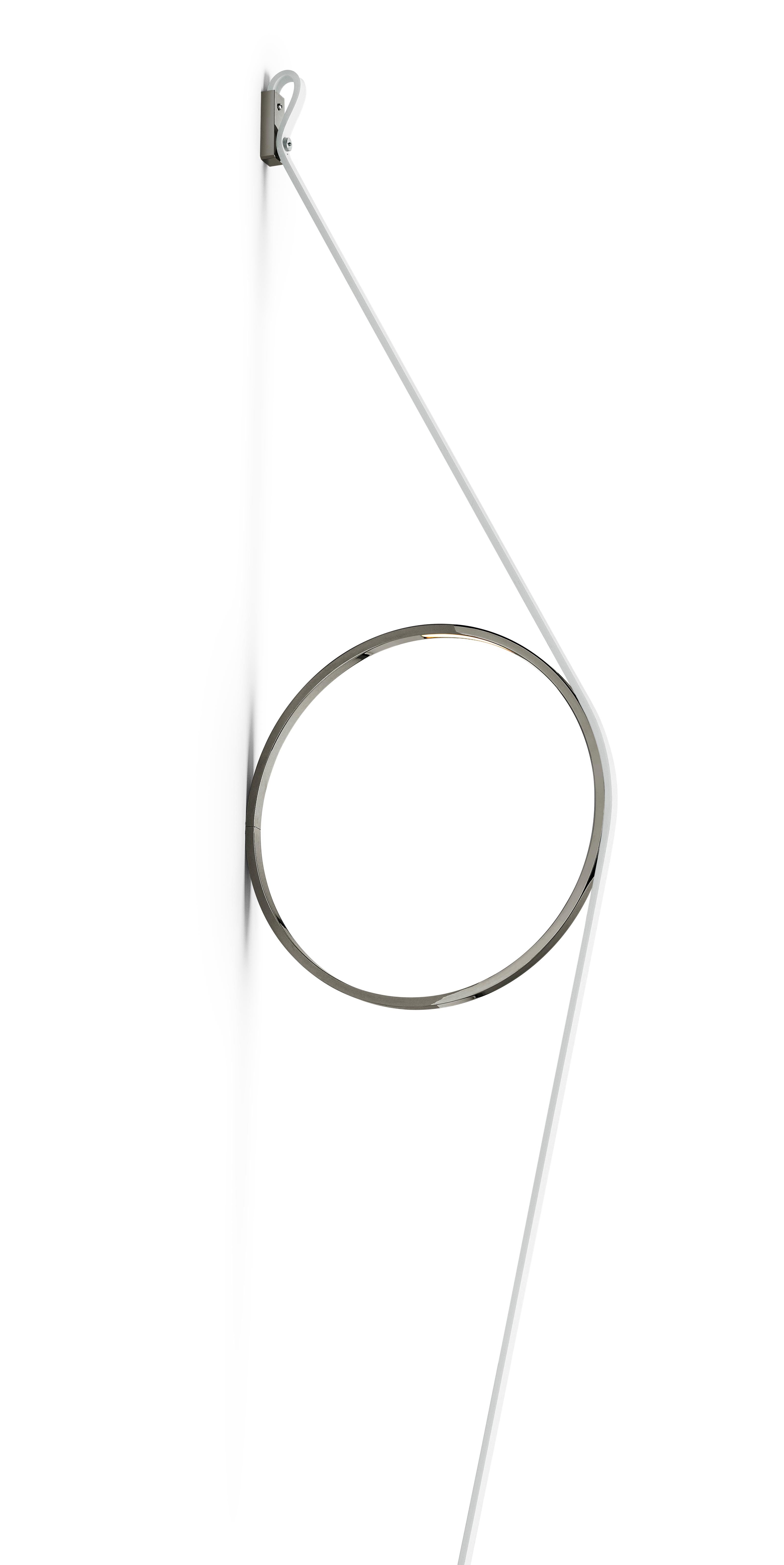 Un esercizio di riduzione, ridotto agli elementi più essenziali, che offre una luce splendidamente resa. Il filo sostiene un semplice anello dotato di una striscia LED. Il cavo e l'anello sono disponibili in diverse combinazioni di colori e in una