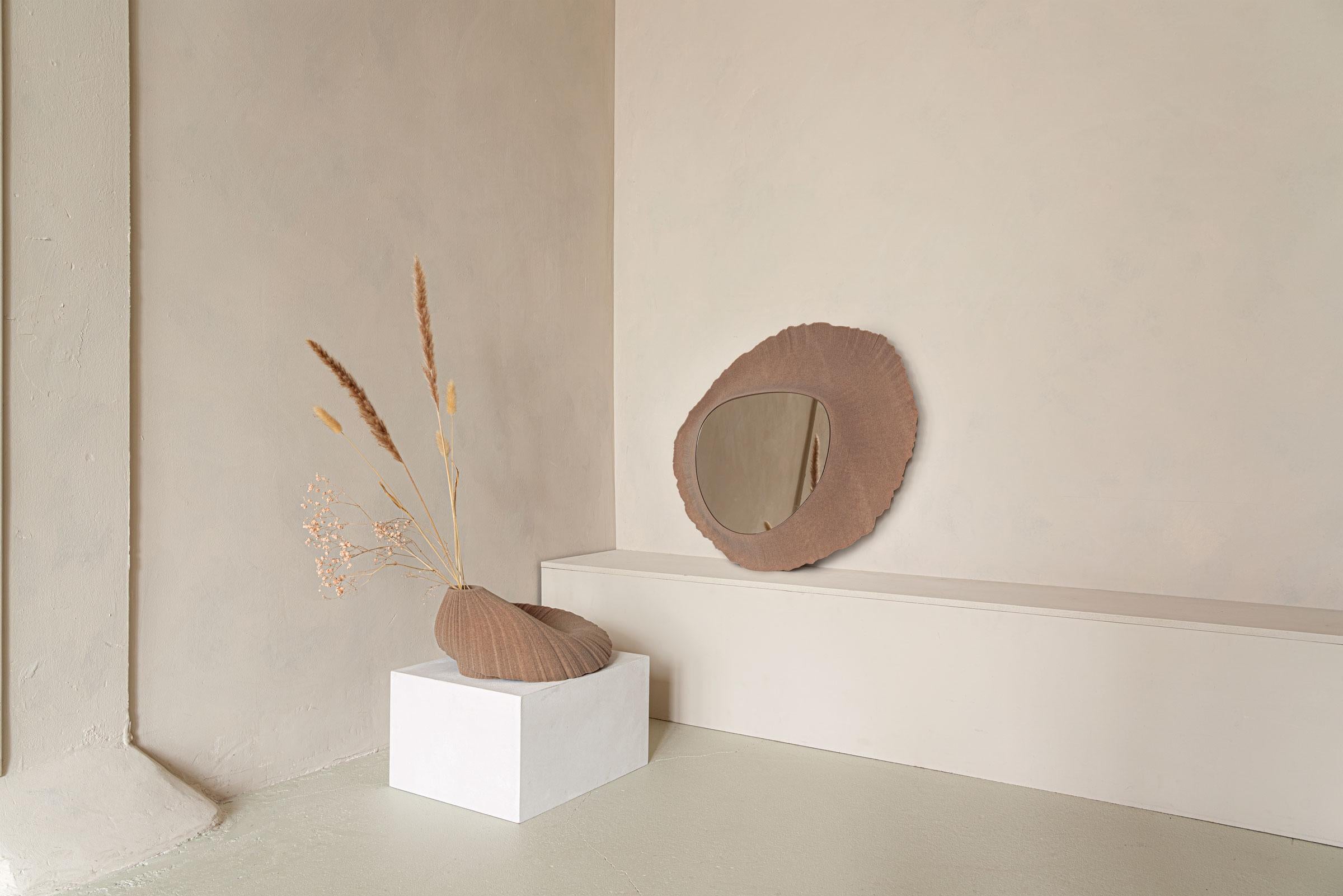 The Flow wall mirror is part of the 'Sand in Motion' collection – a family of sculptural objects manufactured from 3D printed sand, using technology that was developed for the German automotive and aerospace industries. 

The subtle curves, in