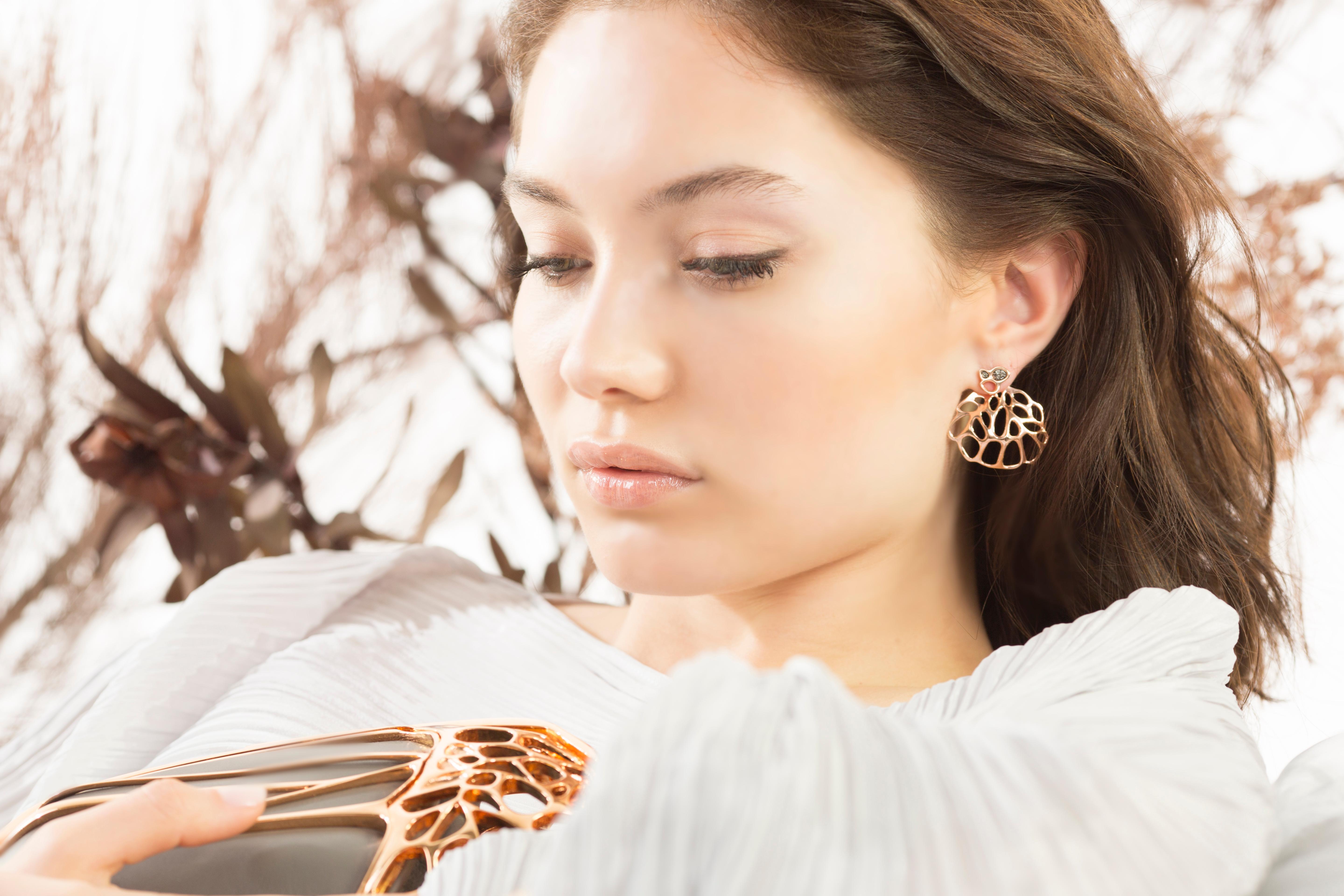 The AODA Studs and Ear Jacket Earrings are intended to recall fossils or futuristic organisms. The intricate geometry radiates a 3 dimensional suspended sculpture when worn.
These visionary pieces, part objet d'art, part artifacts are digitally