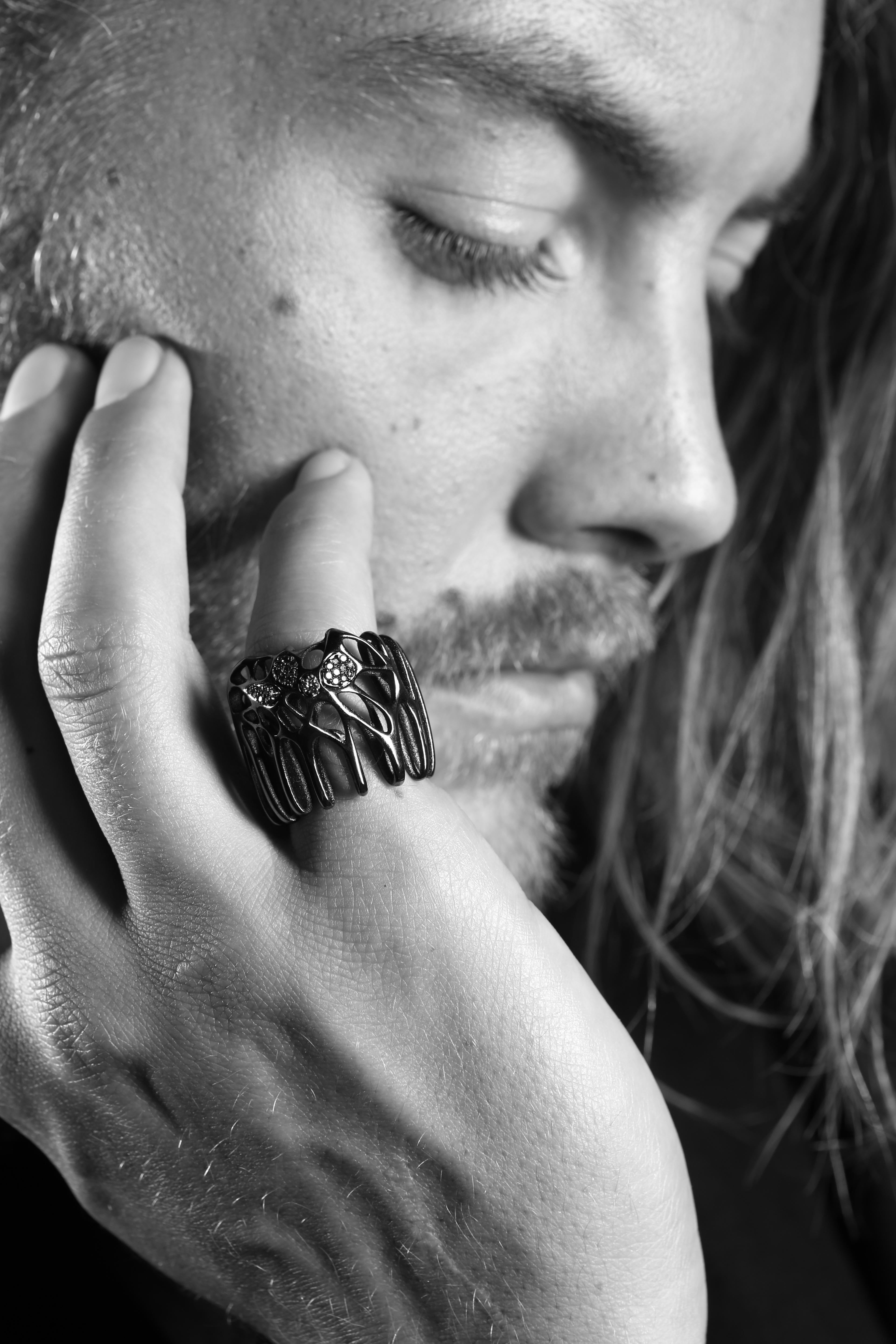 El Anillo de Cóctel MOXI es increíblemente detallado, formando delicadas redes que parecen medio biológicas, medio geológicas y de otro mundo.
Finas nervaduras y bucles parecen crecer alrededor de los diamantes como dedos metálicos de coral, girando