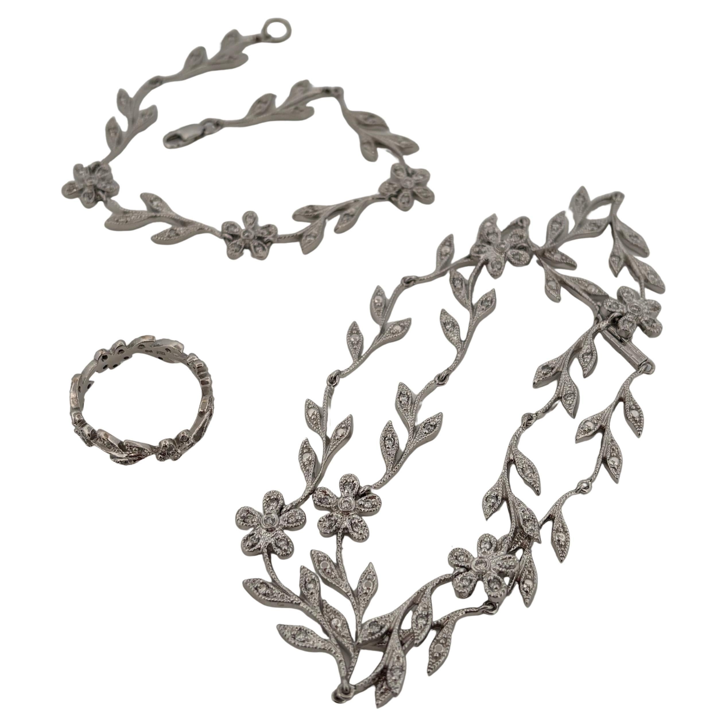 Questa squisita parure in oro bianco 14k sfoggia un motivo floreale senza tempo accentuato da diamanti naturali a taglio rotondo. La collana misura 16 pollici di lunghezza, pesa 21,1 grammi e presenta un peso totale di 0,27 carati di diamanti,