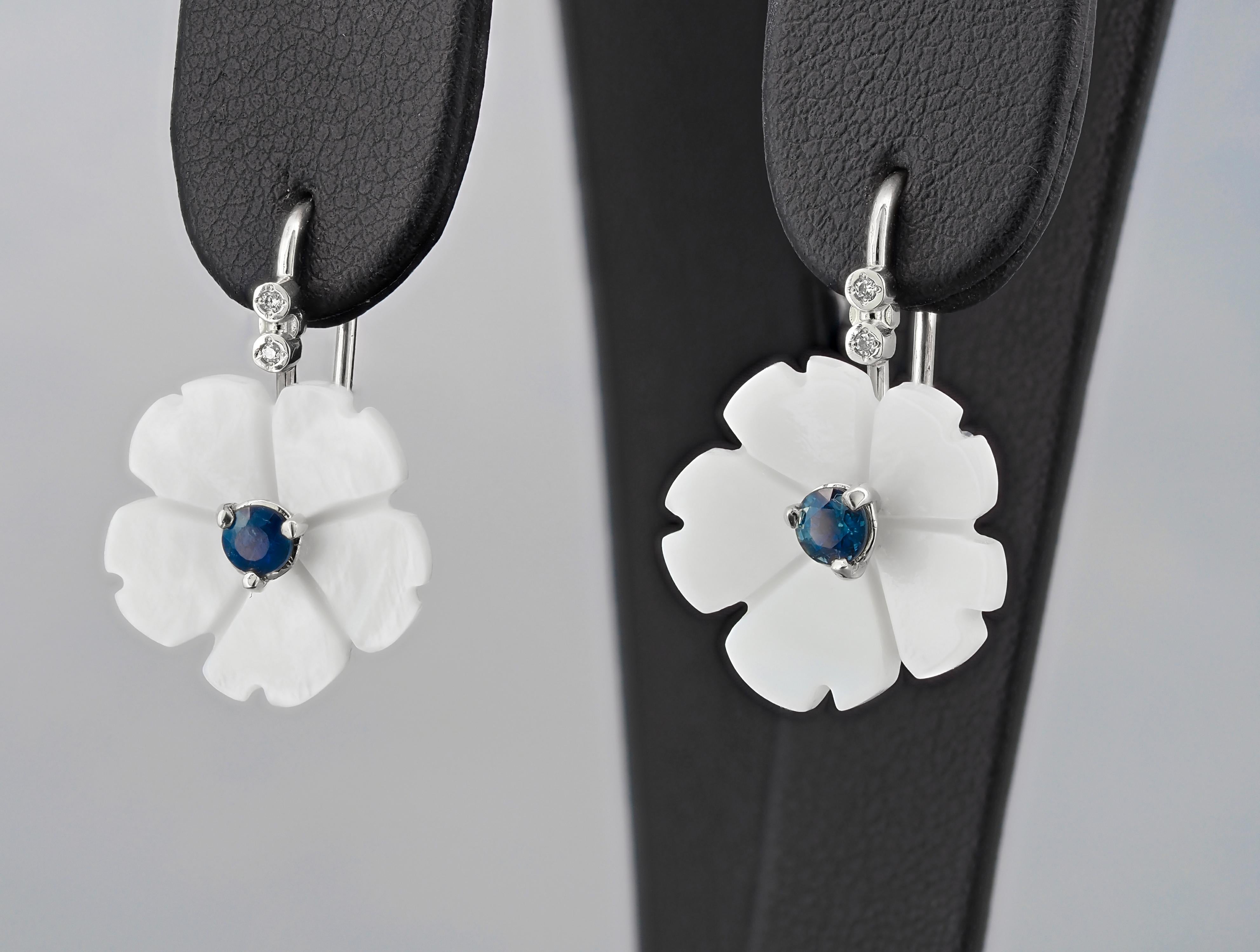 Flower 14k gold earrings with blue sapphires. Blue sapphires and carved mother of pearl earrings. 

Metal: 14k gold. 
Weight: 3 gr
Central stone: Sapphires- 2 pieces 
Cut: Round  
Weight: aprx 0.25 ct. total. 
Color: Blue
Clarity: Transparent with