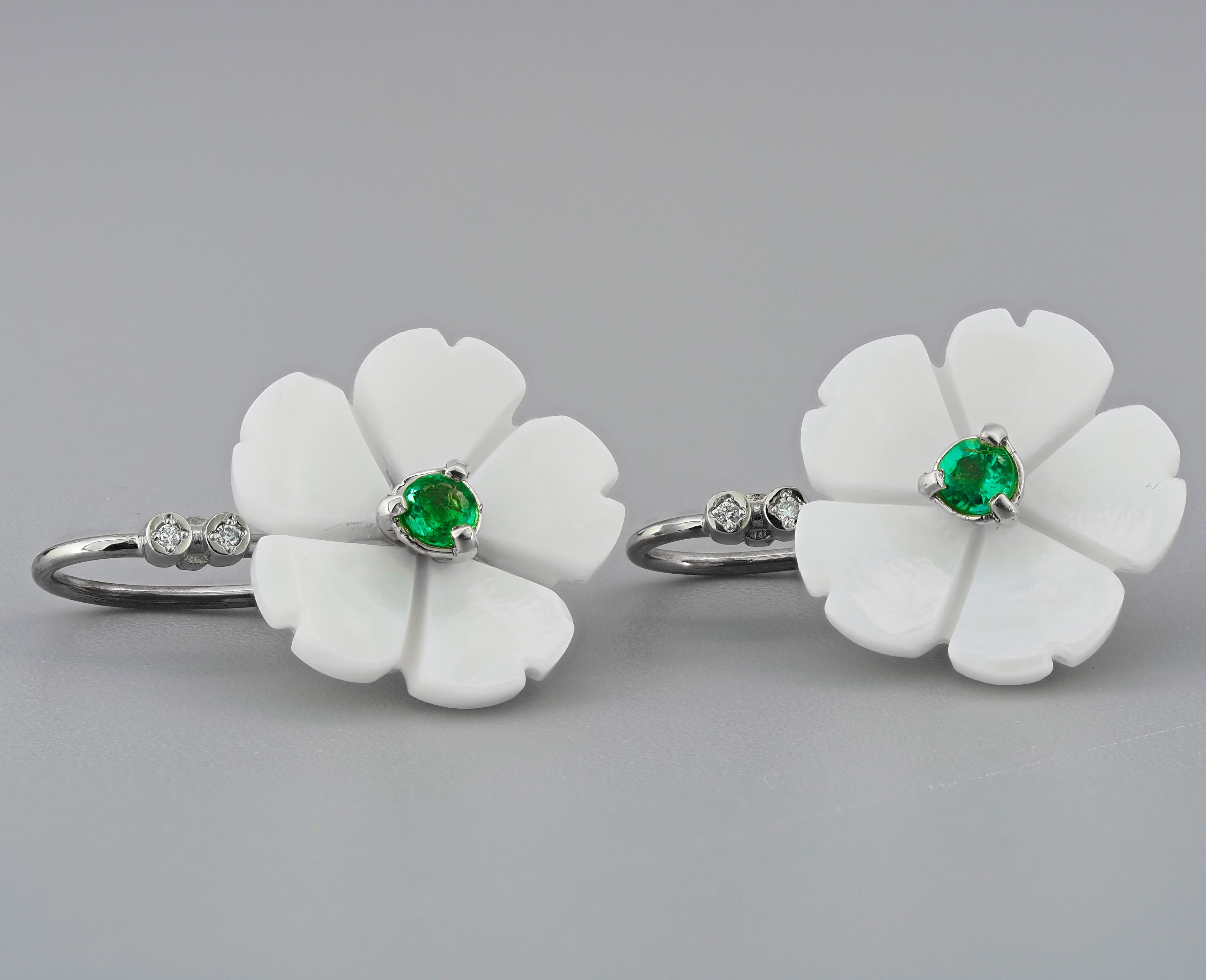 Flower 14k gold earrings with emeralds. 
Emeralds and carved mother of pearl earrings.

Metal: 14k gold.
Weight: 3 gr.

Central stone: Emeralds- 2 pieces
Cut: Round
Weight: aprx 0.25 ct. total.
Color: green
Clarity: Transparent with inclusions (See