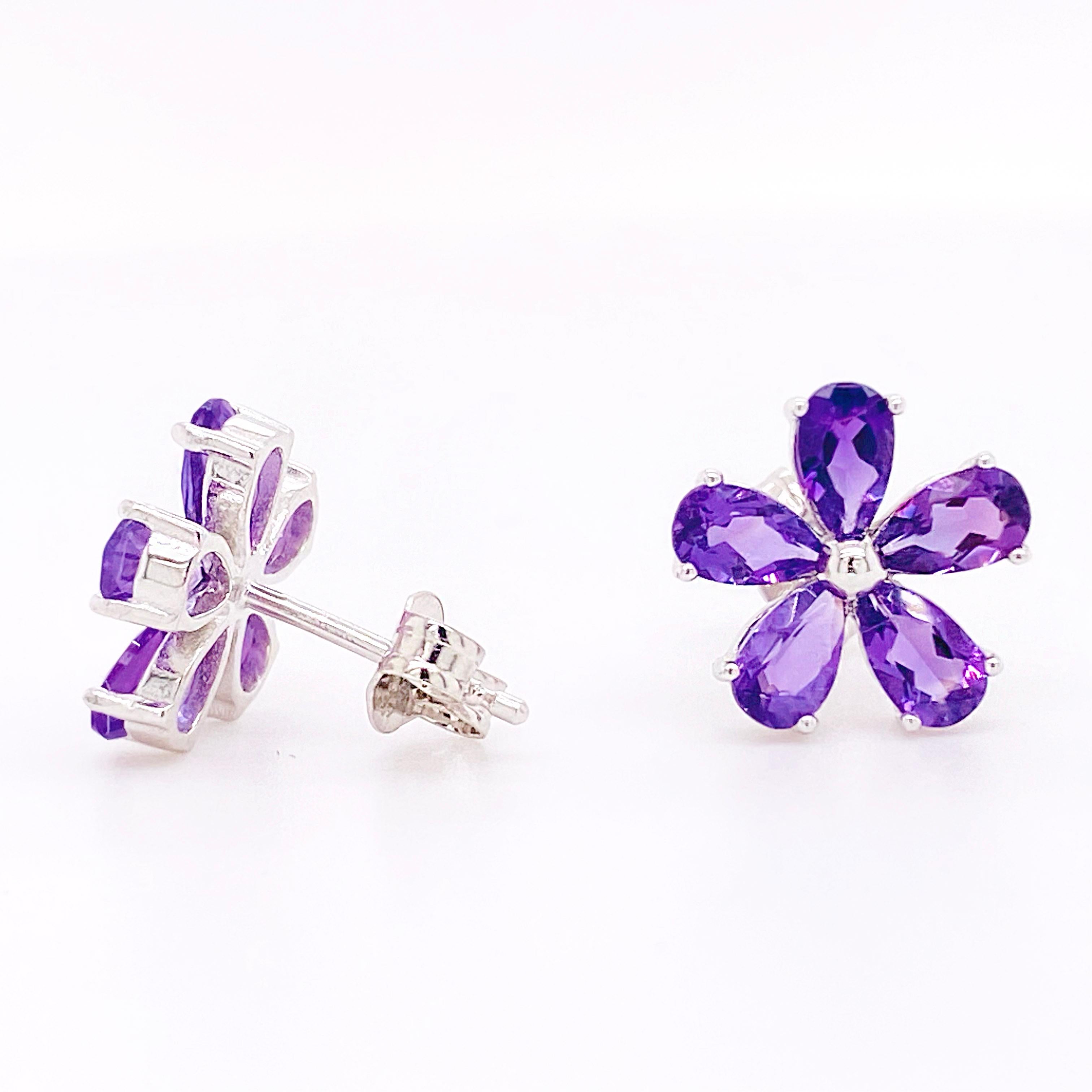 These amethyst flower earrings are perfect for anyone that loves bright and vibrant floral designs. The perfectly cut pear shaped amethysts sparkle brightly as they circle the center bright sphere of silver to form a five petal flower! The details