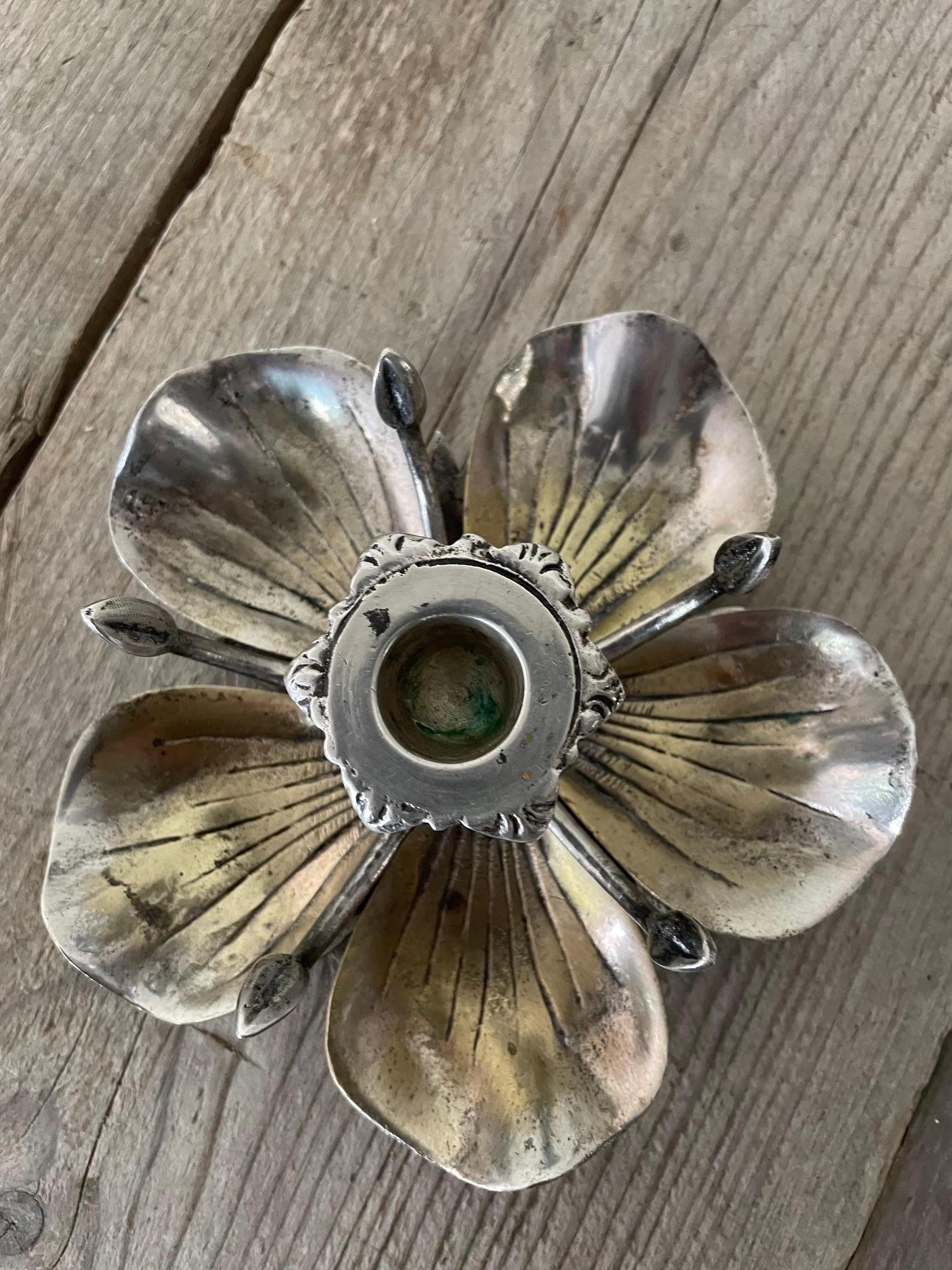 Cendrier et bougeoir à fleurs attribués à Gucci en métal argenté.
Celui-ci est original car il possède les 5 pétales du cendrier mais aussi un chandelier au centre, ce qui est inhabituel.