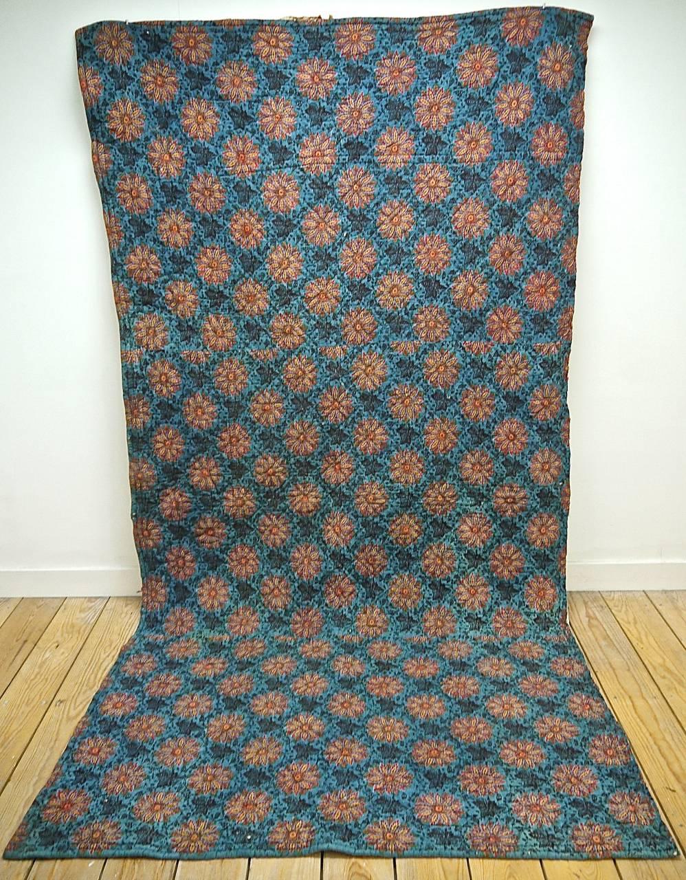 French circa 1820s cotton block-printed quilt section in a striking design of bright saffron yellow and madder stylised flower heads surrounded by dark leaves on a blue pastel ground.The reverse is a simple allover print.
With some small repairs.