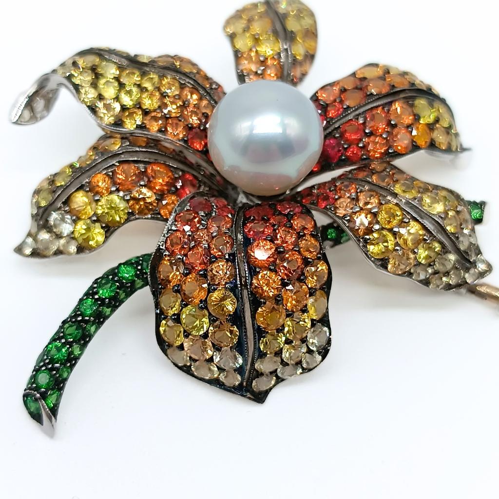 Flower Brooch in White Gold with central Pearl 
Six Petals with 250 Yellow Sapphires in degrade 
Stem with 53 Tsarorites, all in Round-Cut
18k Gold 17,29gr
53 Tsavorites 1,00k
250 Yellow Sapphires 13,53k


