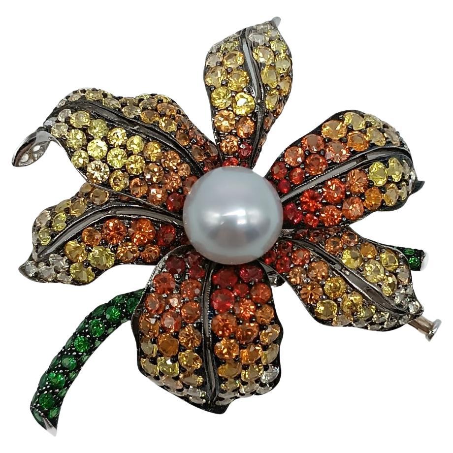 Broche fleur en or blanc avec perles, saphirs et tsavorites en vente