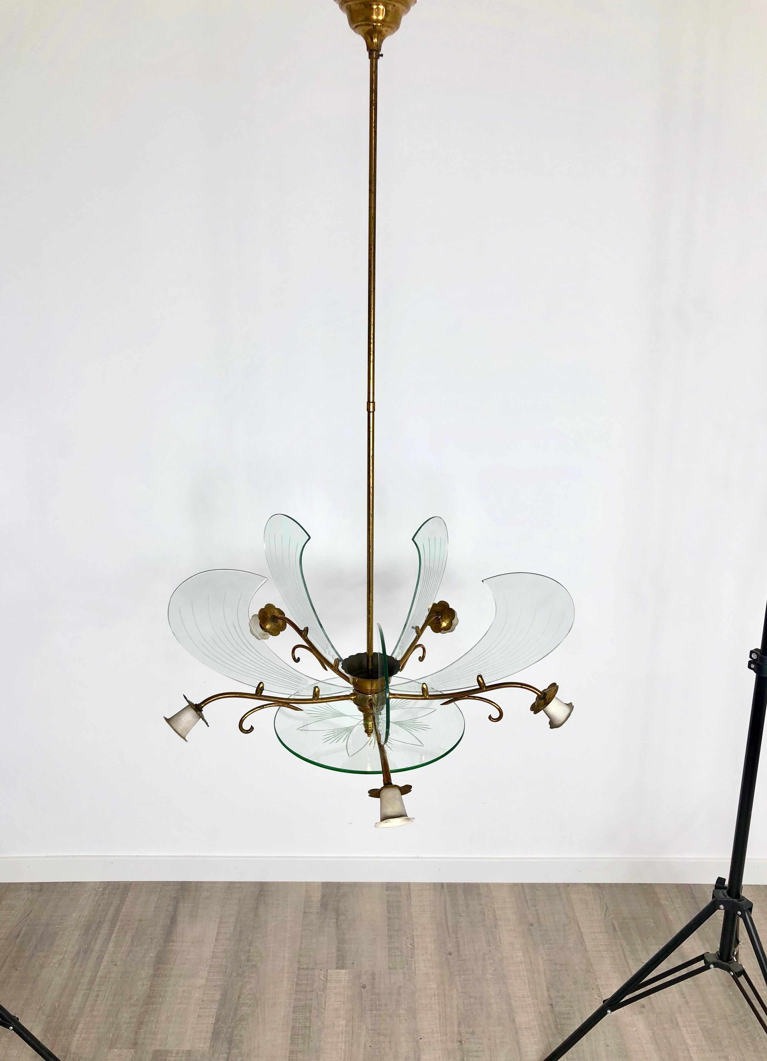 Chandelier by Fontana Arte made in the shape of a flower with glass petals and brass stem and thorns. The glass is embellished with floral details and it features five light bulbs. Made in Italy, circa 1950.
As the photos show, the brass shows time